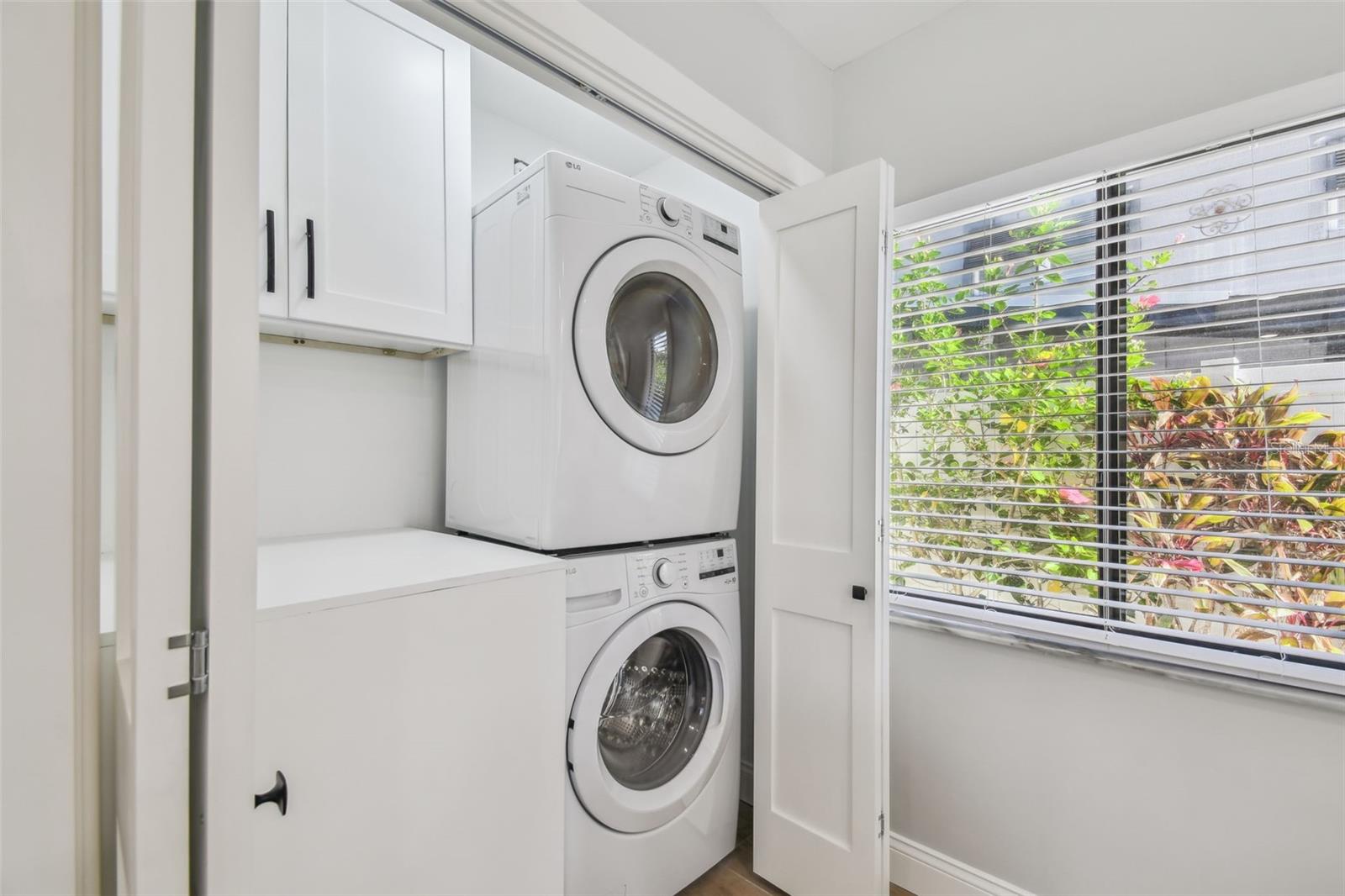 Brand new laundry closet that comes with brand new, full size washer and dryer with folding area and storage cabinet above