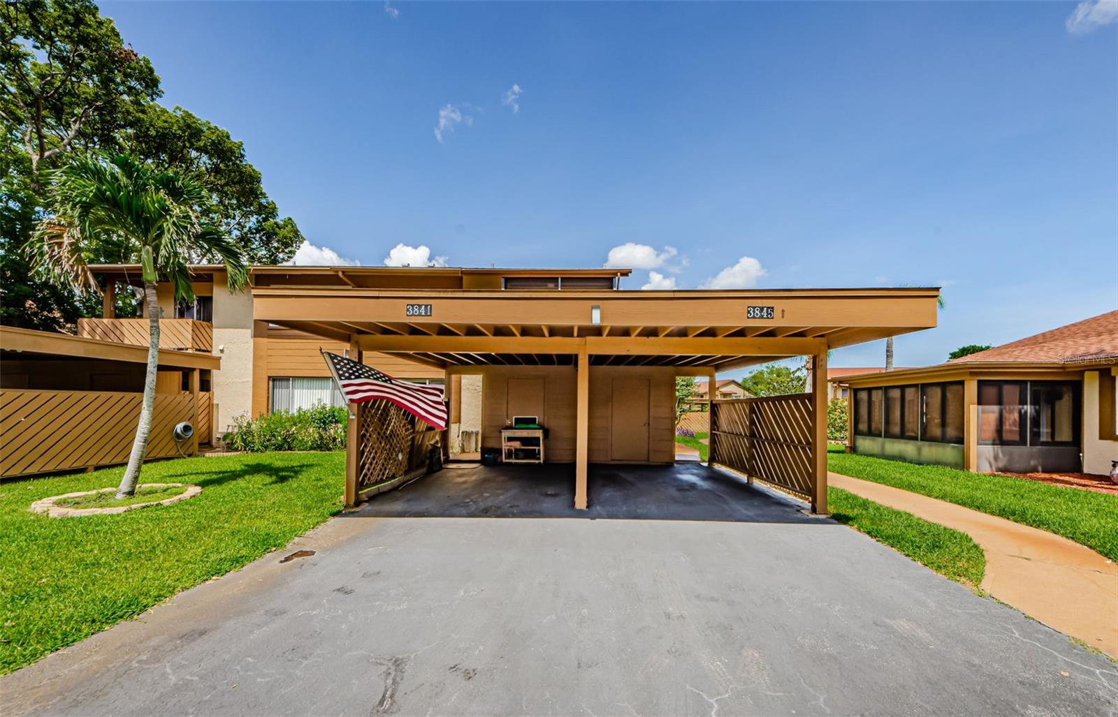 Covered Carport on the left with access to the kitchen through the outdoor lanai