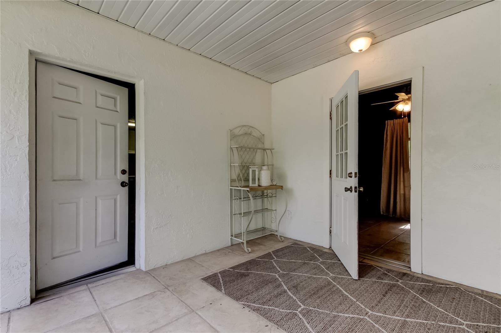 Patio area between house and garage with entrance to bonus space