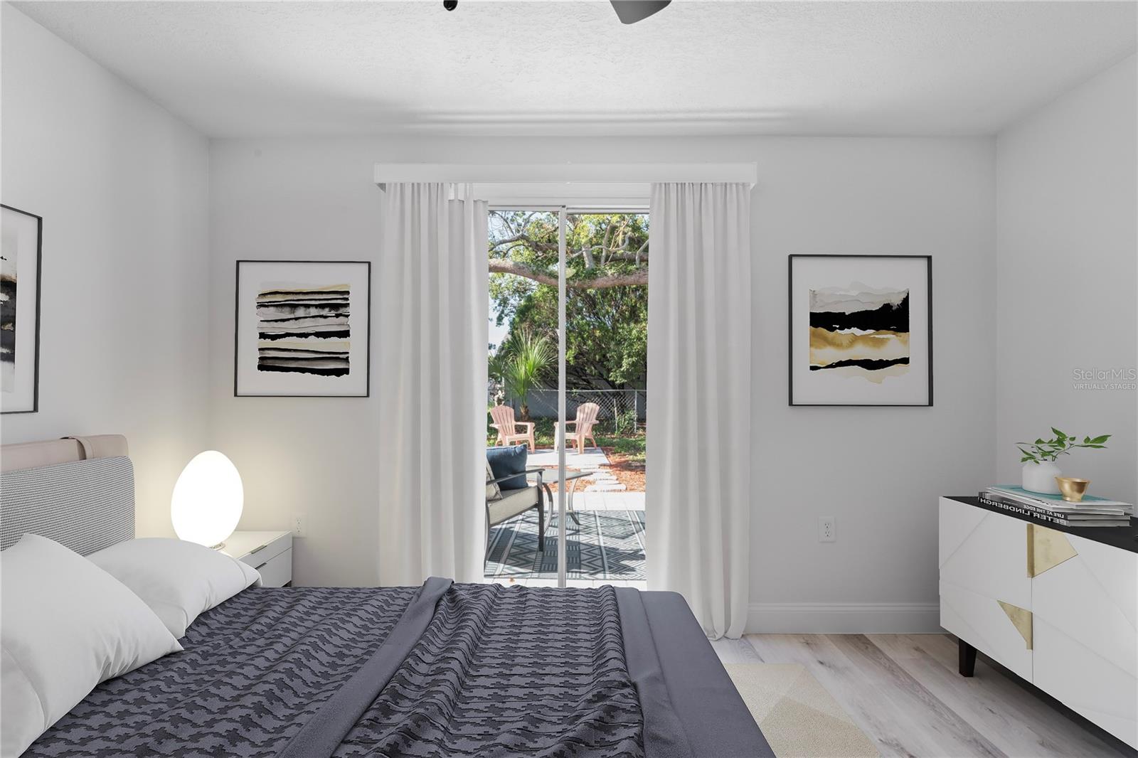Primary bedroom with patio access virtually staged