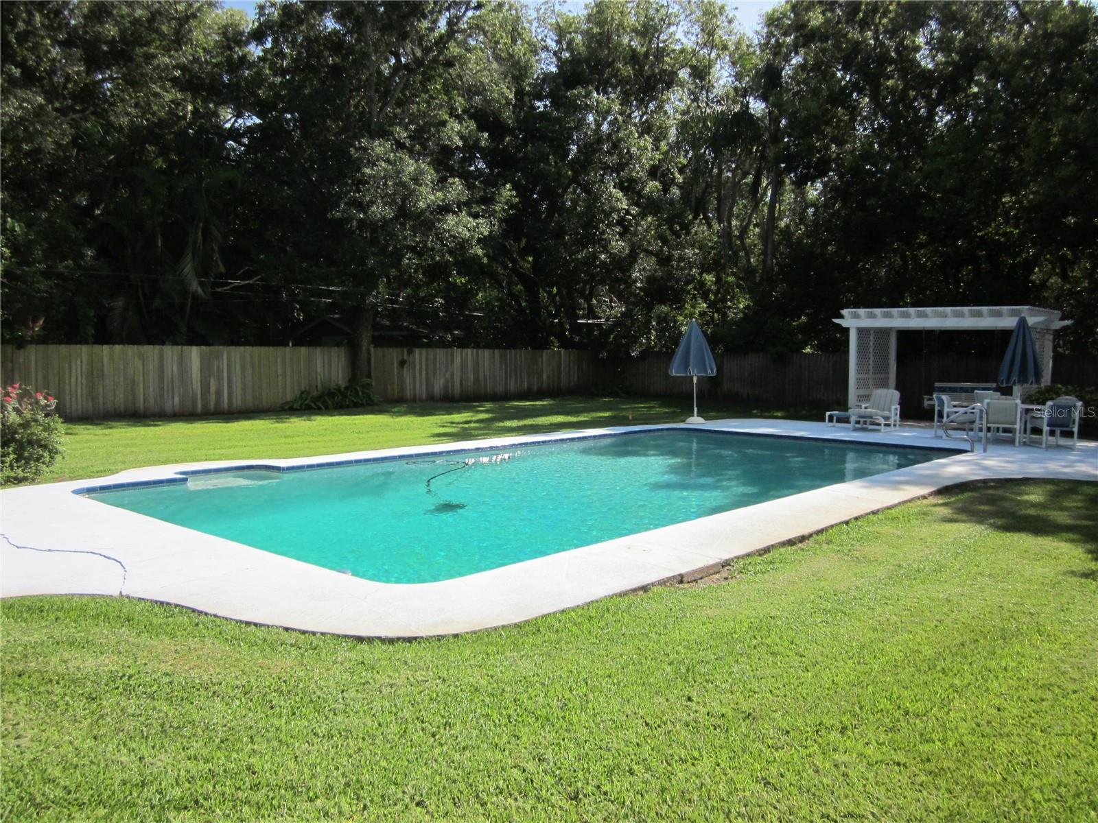 Very large lap pool in the picturesque fenced back yard