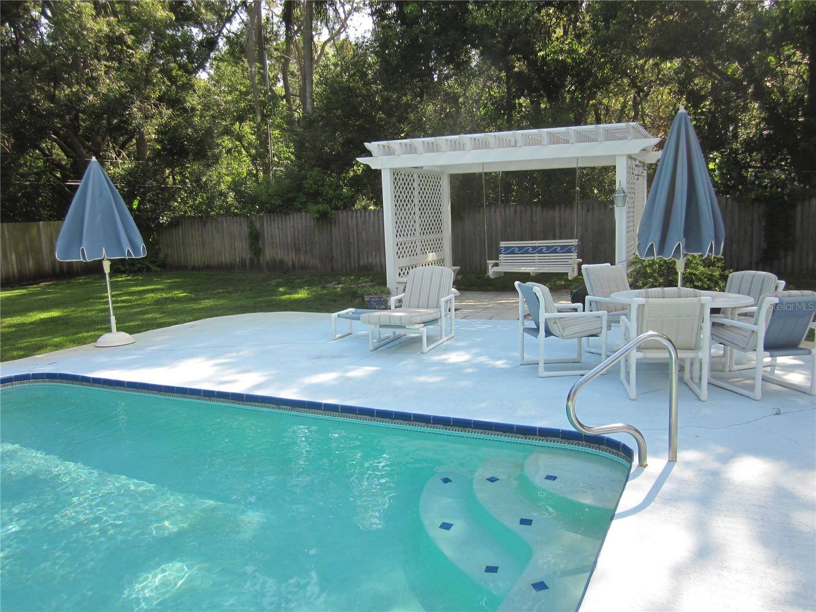 Relaxing deck area with pergola, porch swing & plenty of room to entertain