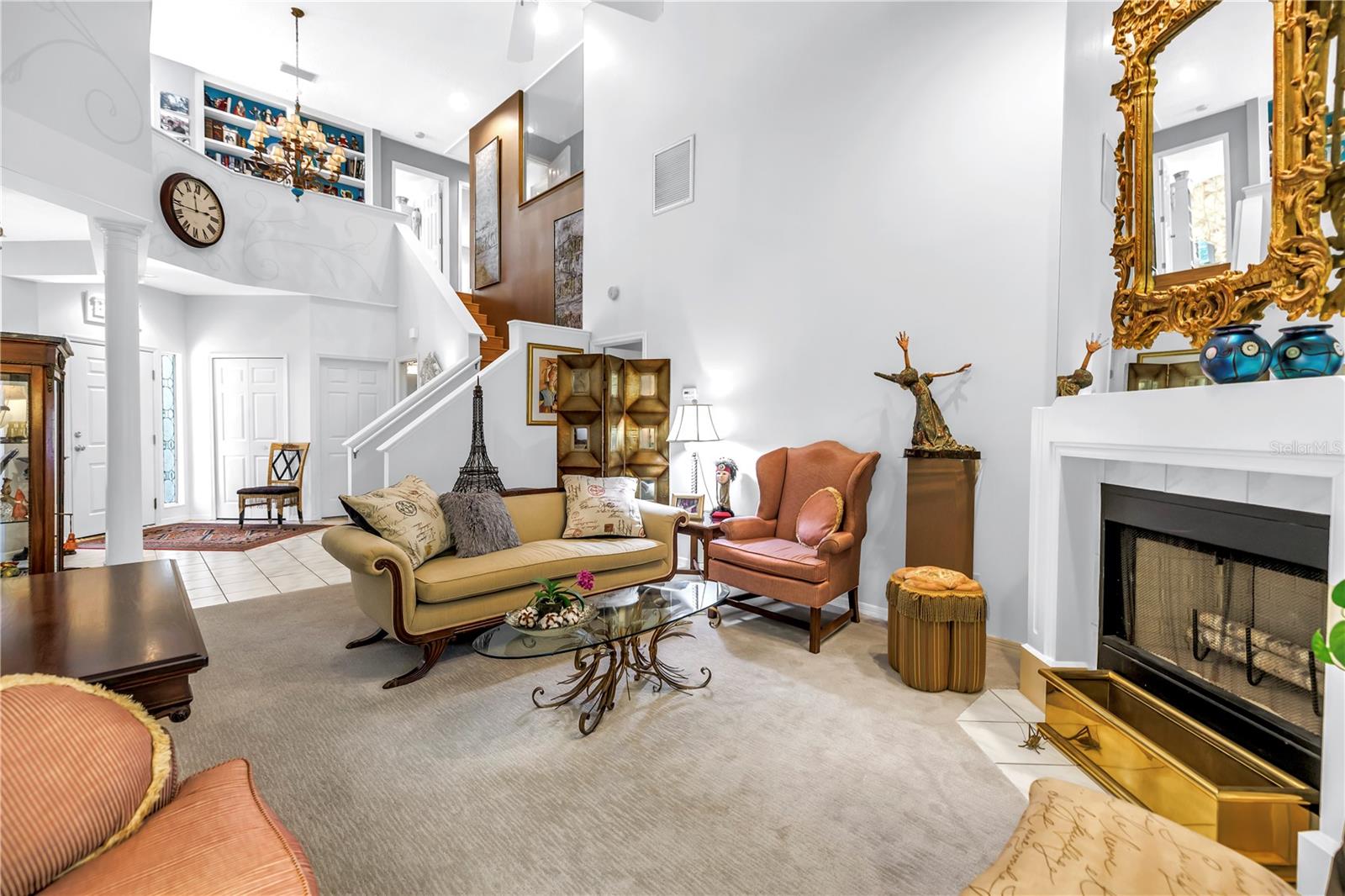 View of Balcony, Wood Burning Fireplace with Custom Curated Fireplace Surround,  Tall Ceiling and Open staircase are perfect for hanging artwork