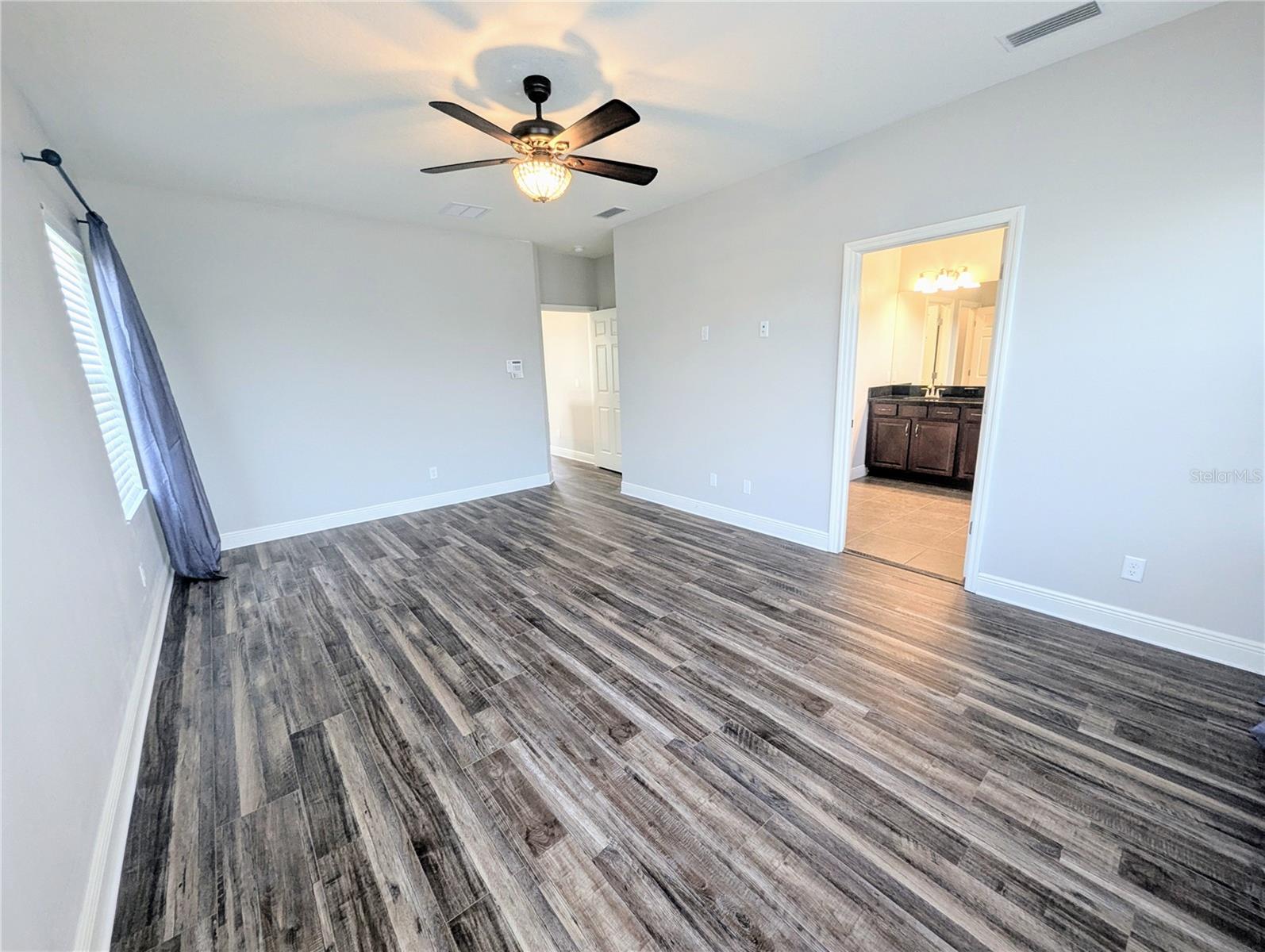 Primary Bedroom with an en suite bathroom, walk-in closet, and dual sinks.