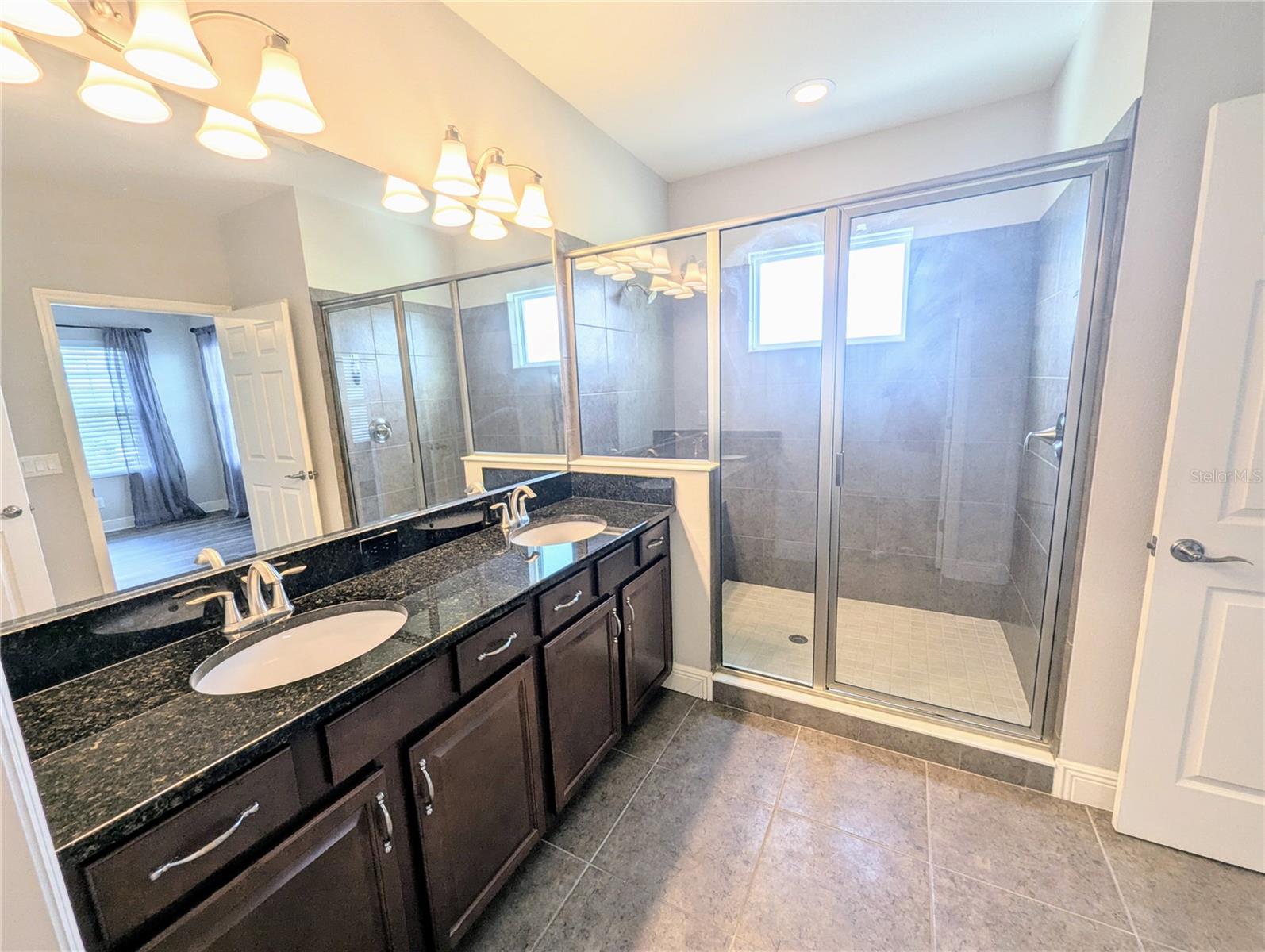 Primary Bedroom with an en suite bathroom, walk-in closet, and dual sinks.