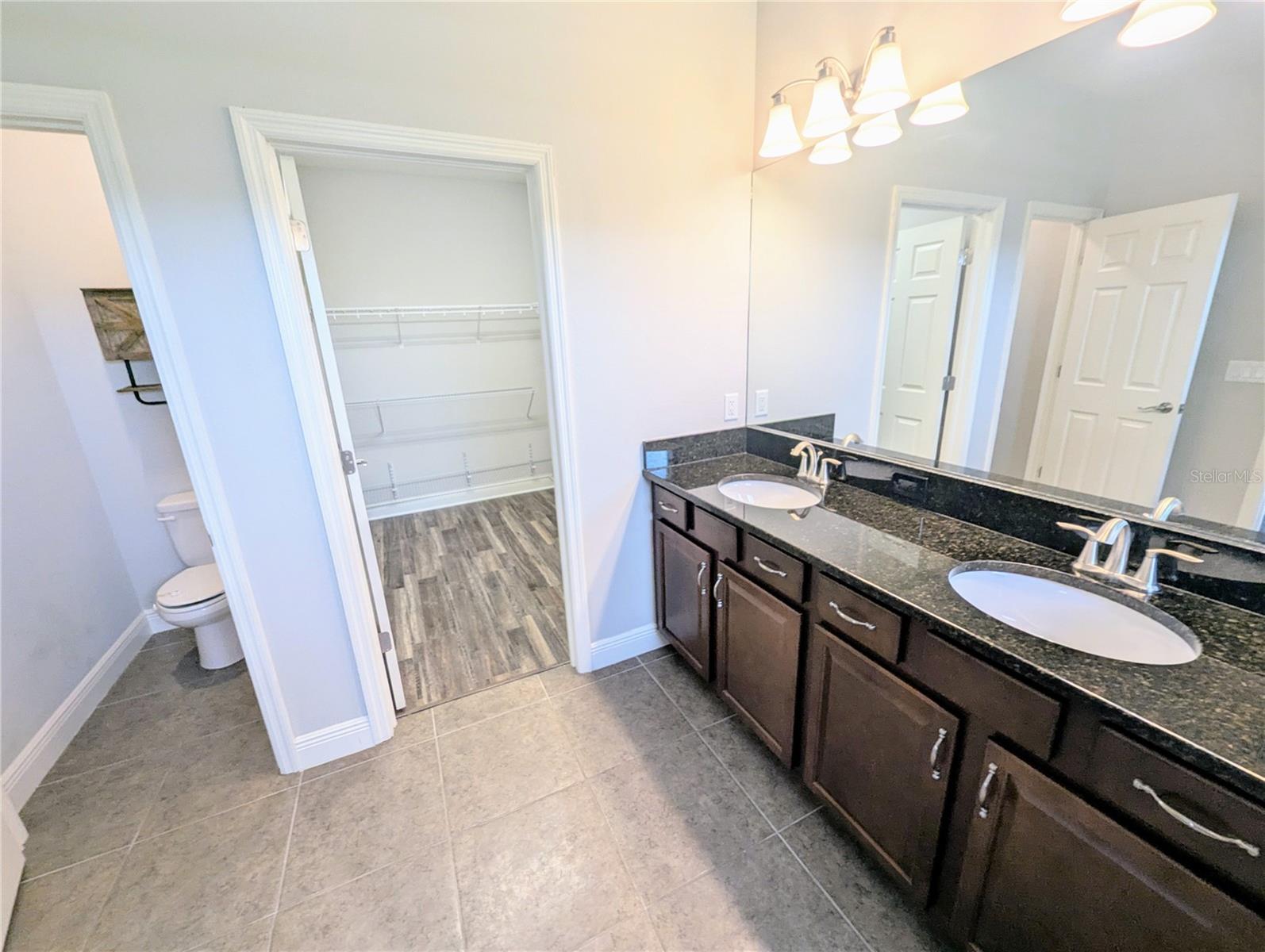 Primary Bedroom with an en suite bathroom, walk-in closet, and dual sinks.