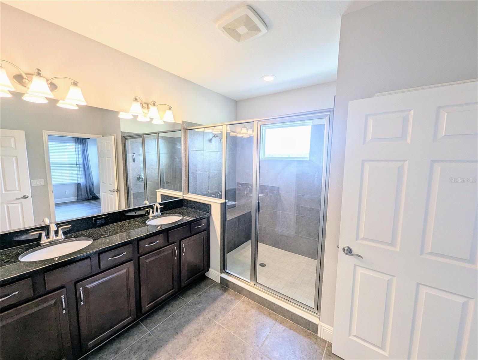 Primary Bedroom with an en suite bathroom, walk-in closet, and dual sinks.
