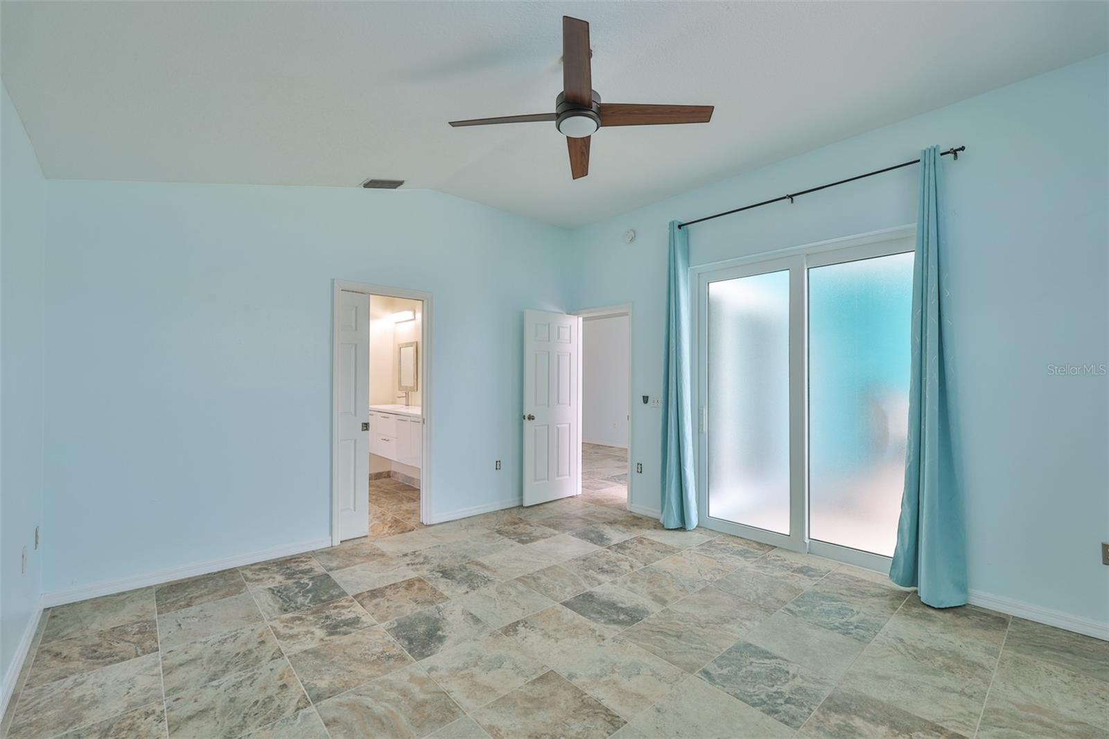 Primary bedroom, hurricane sliders, en-suite bathroom and walk-in closet