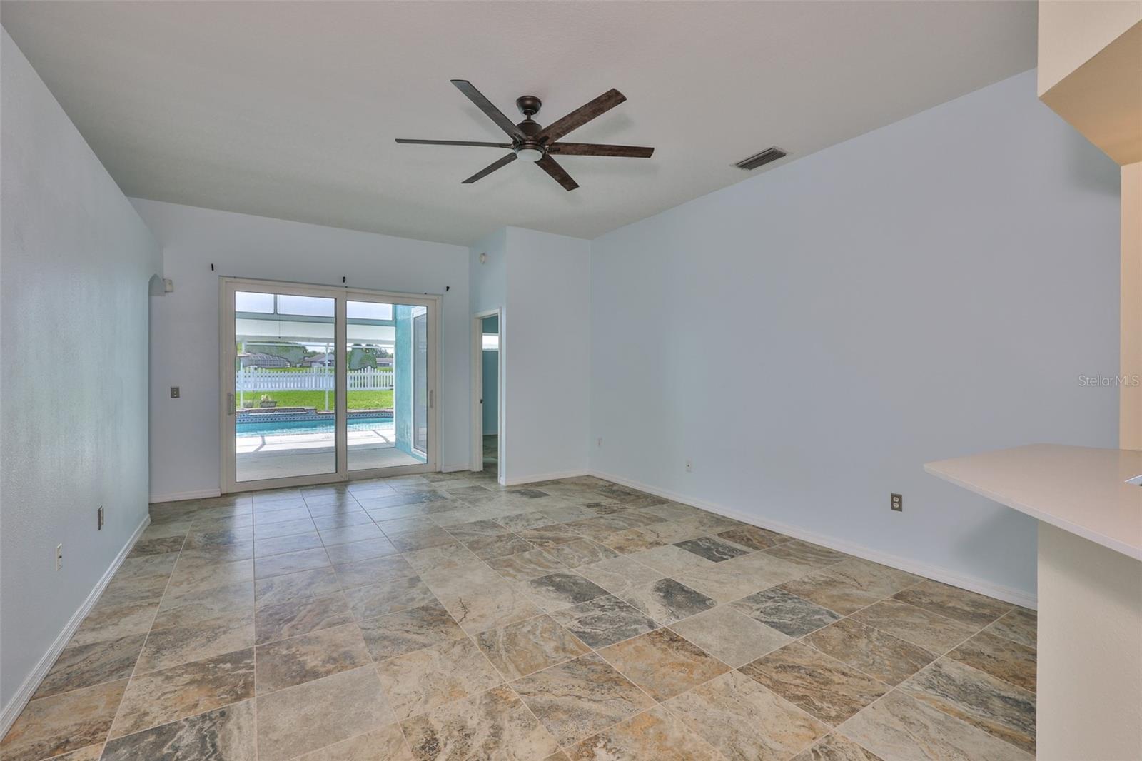Great Room, primary bedroom far right, center hurricane sliders to lanai, pool, pond and fenced yard