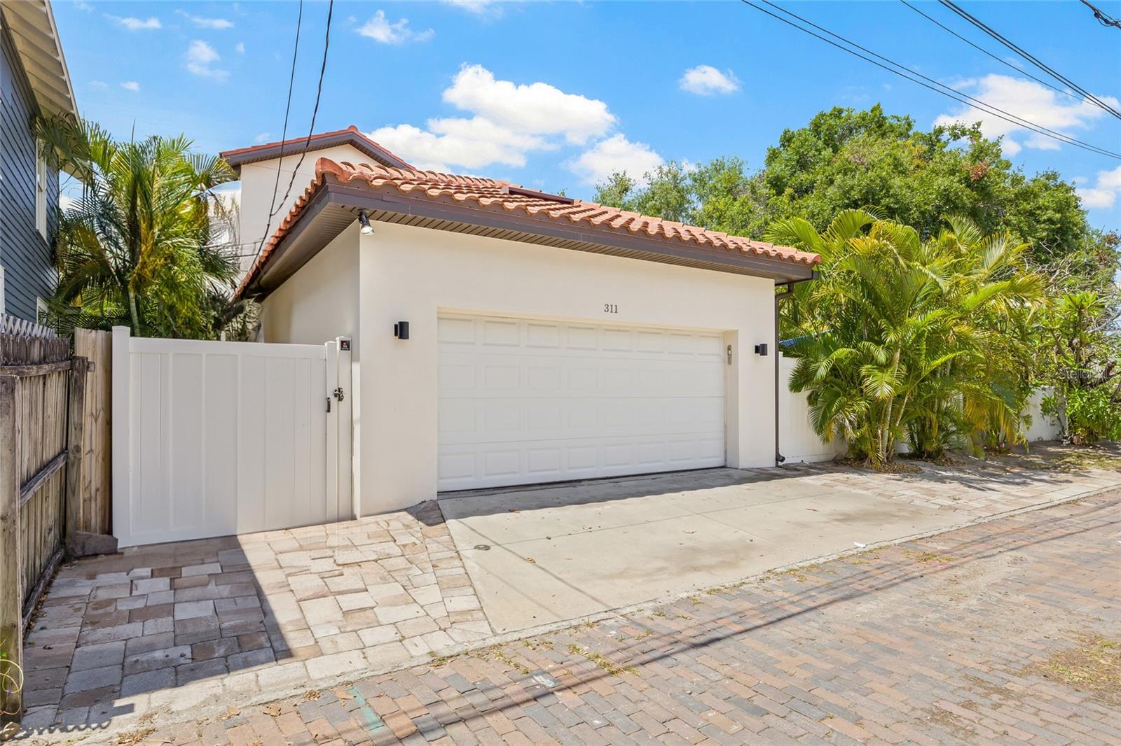 Two car garage with large parking pad and brick alley.