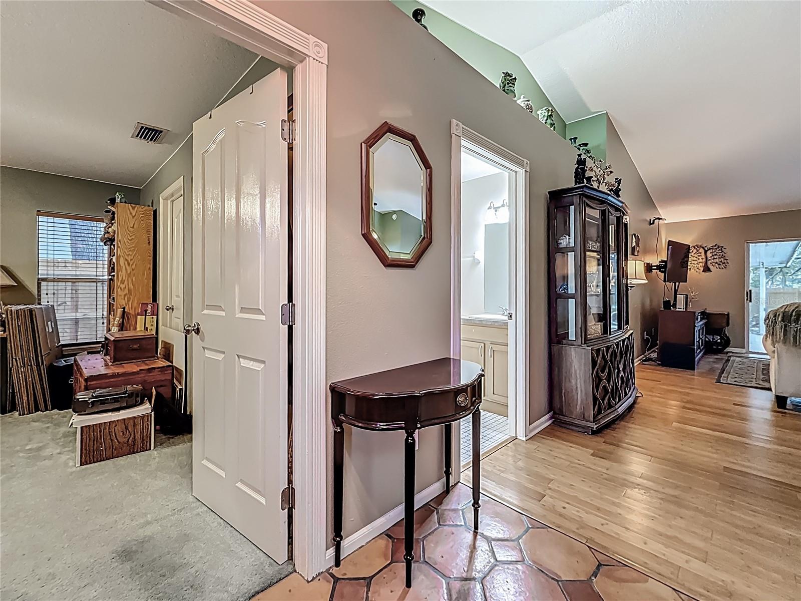 Your back is to the front door. This is the view into bedroom #2. Please also take note of the vaulted ceiling and display area with lights above the 2nd door (hall bath / Jack n' Jill Bath)