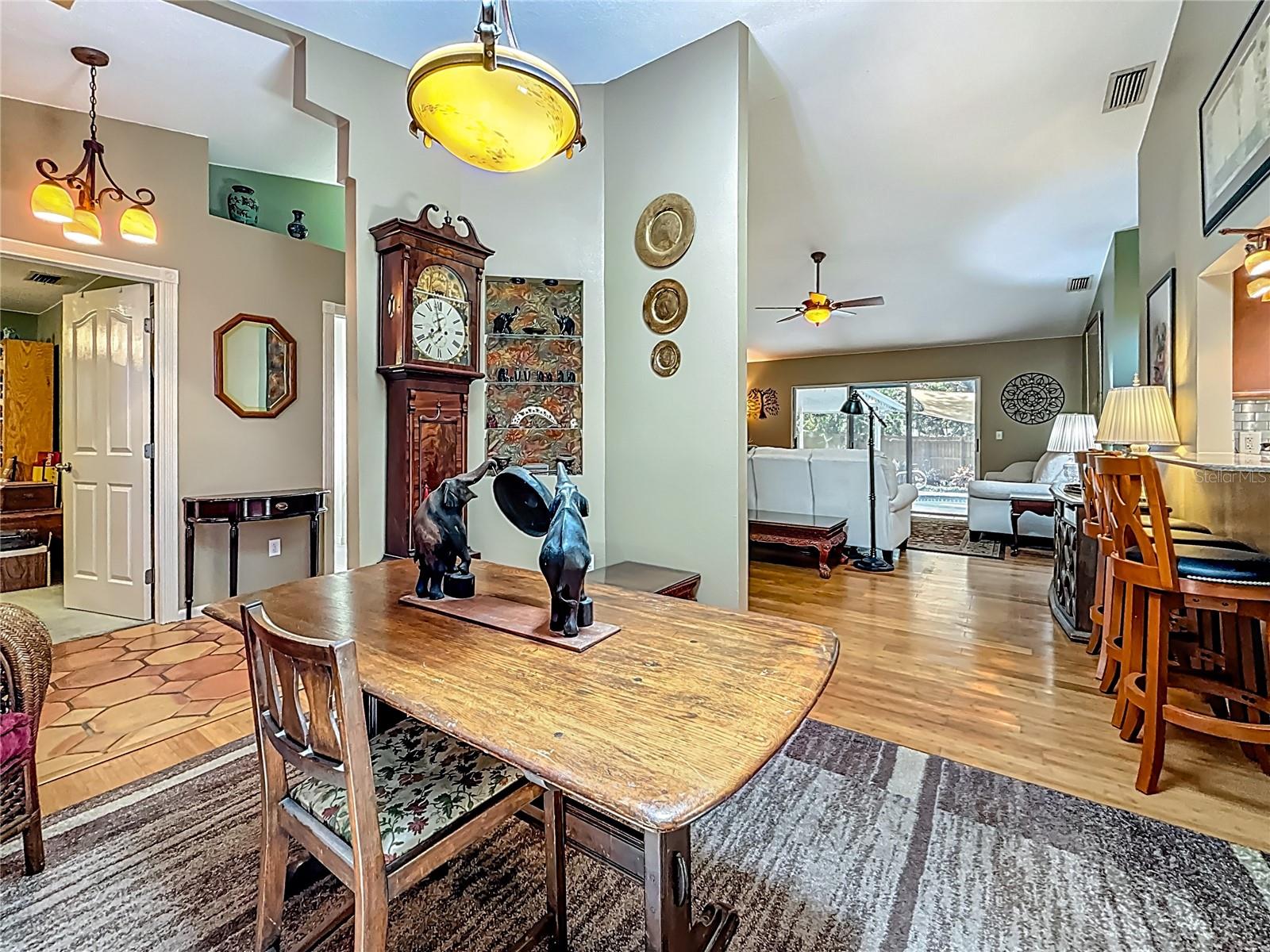 You are in the dining room with a view into the living room. The door on the left is Bedroom 2. Did you notice the breakfast bar to your right?