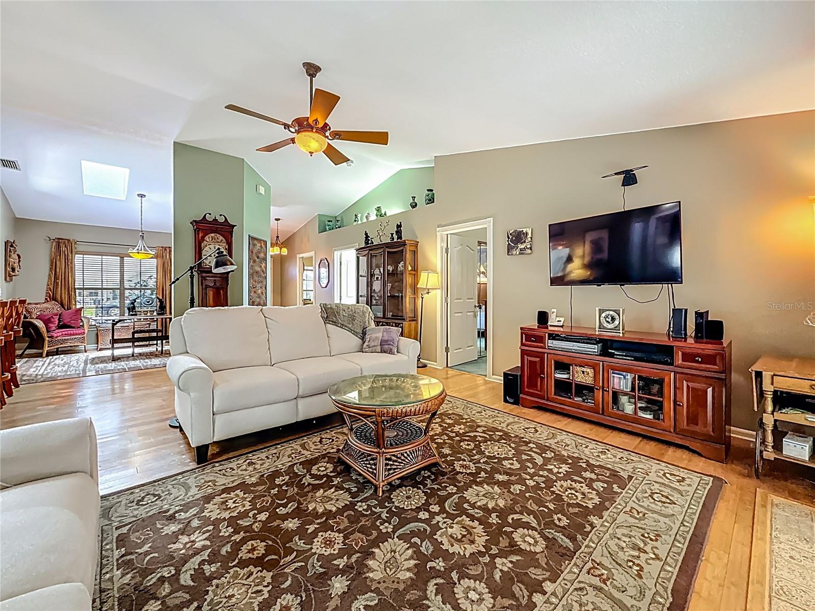The sliding doors to the lanai are to your right. This is a longer view into the full living room. Open door to the right leads to bedroom 3.