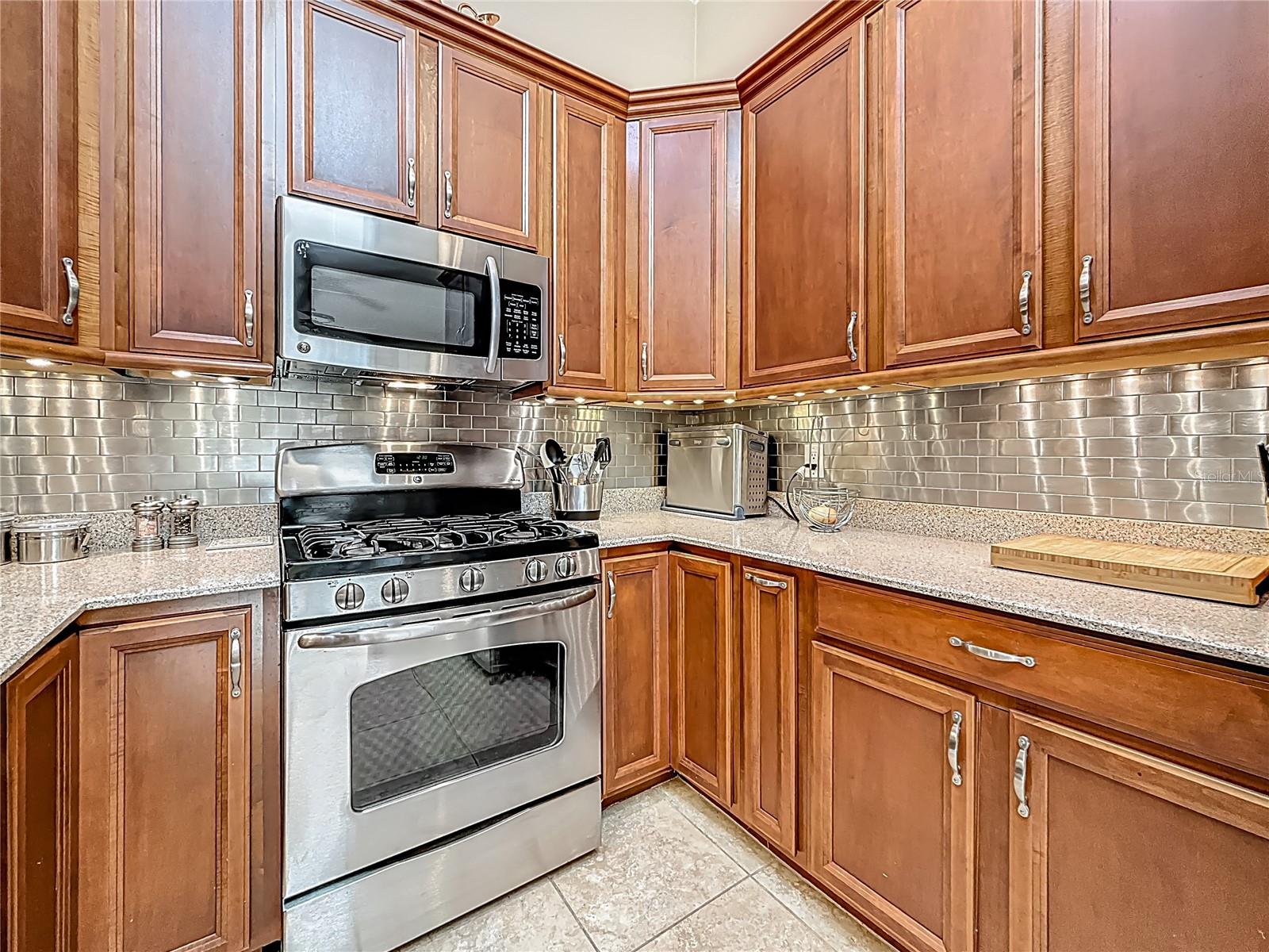 Closer view inside the kitchen. The narrow lower cabinet, next to the corner cabinet, is a pull out spice cabinet. I wish you could see the top of the range so you could notice the extra center burners for griddle pan! If you like to cook, you'll understand my excitement about it!!