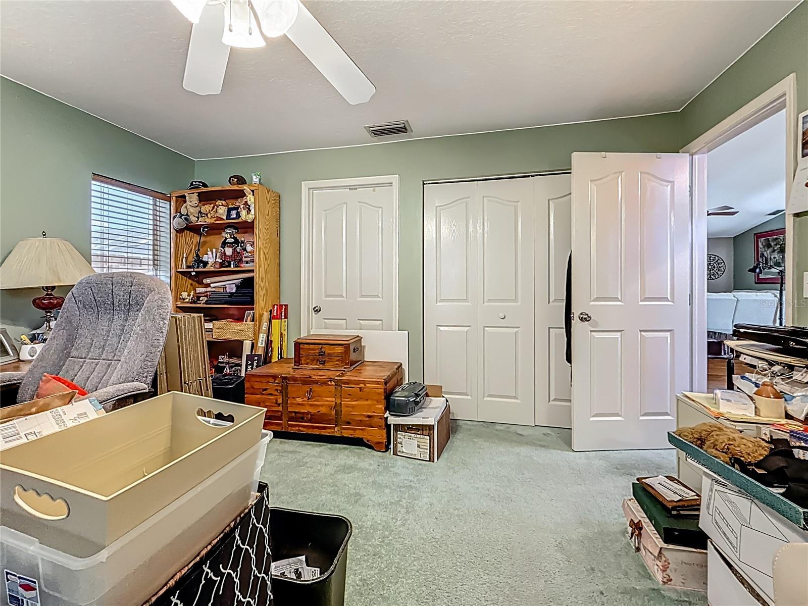 Another view of bedroom 2. Here you will notice the left door leading to the Jack n' Jill bath and the double door is  the wall closet. The closet features both an upper & lower shelf with hanging rods.