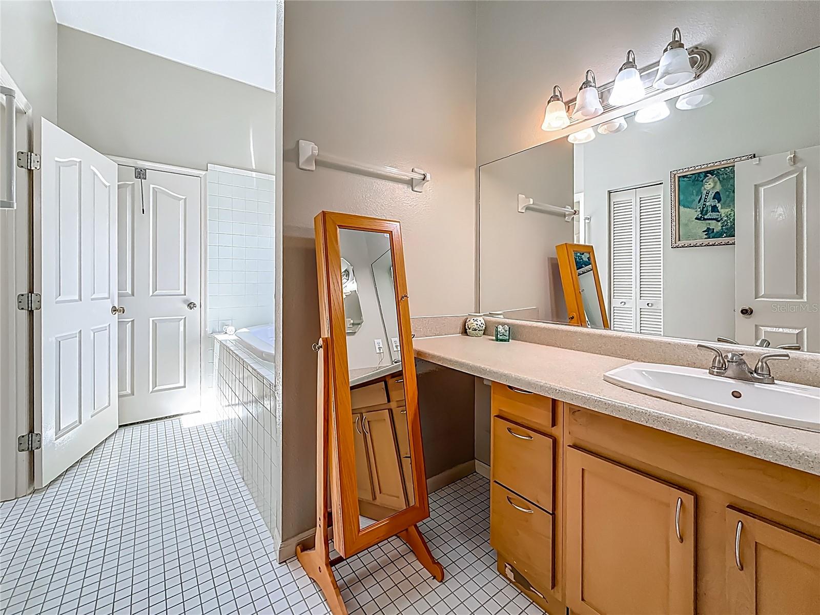 Your back is to the door of bedroom 3, view into the 2nd side of the Jack n' Jill bath. The open door leads to the commode & other vanity. You may notice the louvered doors through the mirror? That is the linen closet.