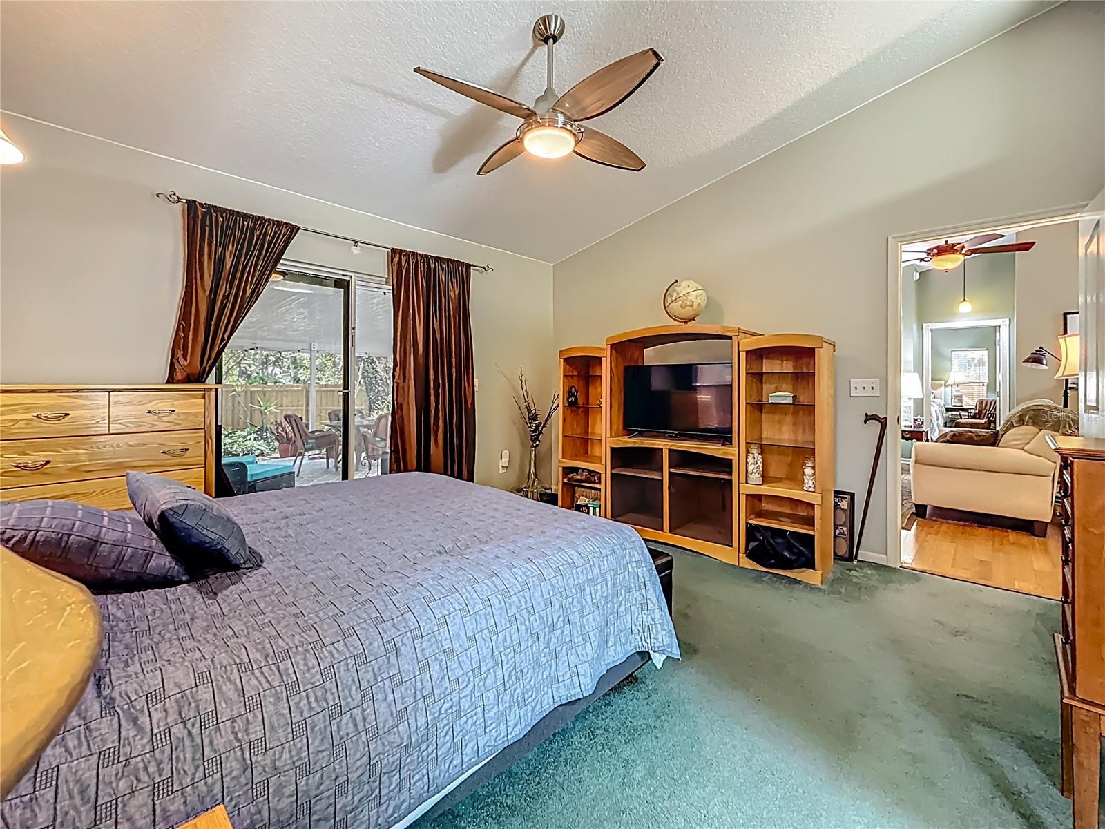 Bedroom 3 - 14.8 x12.9, with vaulted ceiling, walk-in closet & sliding door to the covered lanai & pool. The door to the Jack n' Jill bath is now to your right. Did you may notice the living room through the doorway?