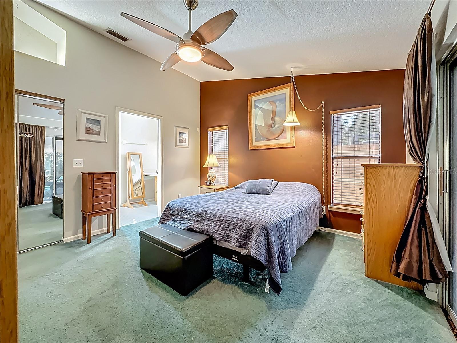 Bedroom 3. In this view, the mirrored door is the walk-in closet ( with 2 sets of shelves & hanging rods). The sliding door to the lanai is to your immediate right. The entrance to the Jack n Jill bath is the open door. Did you notice the shelving, with light, above the closet?