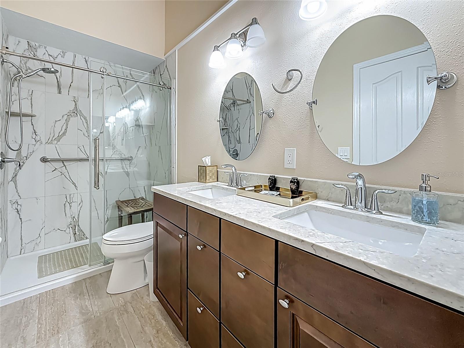 Updated Primary Bedroom en-suite bath with double vanities & tile flooring.