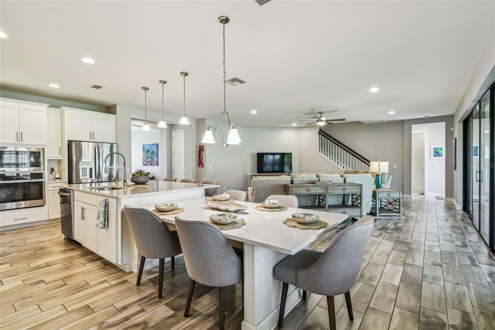 Upgraded Gourmet Kitchen w/Gas Range, SS Appliances & Hood, Built-in Oven & Microwave, Extended Cabinets, Ultra Island, Tile Backsplash, Quartz Countertops, R/O Water Filtration, Walk-in Pantry, & Plantation Shutters