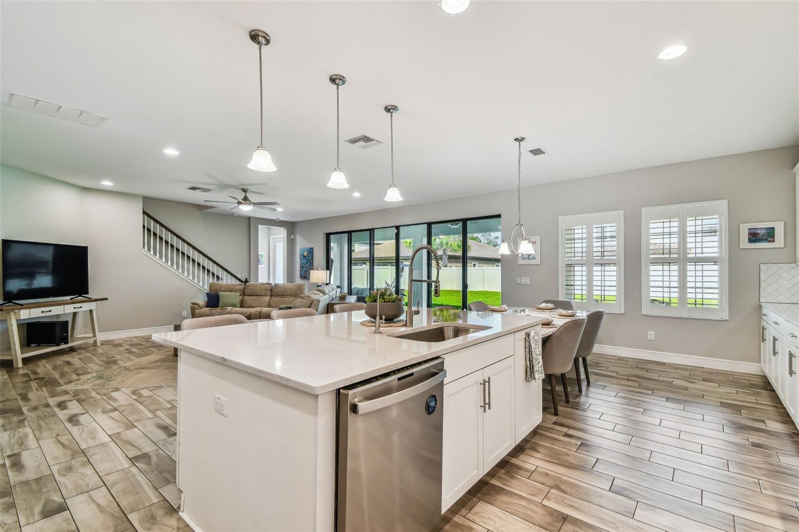 Upgraded Gourmet Kitchen w/Gas Range, SS Appliances & Hood, Built-in Oven & Microwave, Extended Cabinets, Ultra Island, Tile Backsplash, Quartz Countertops, R/O Water Filtration, Walk-in Pantry, & Plantation Shutters