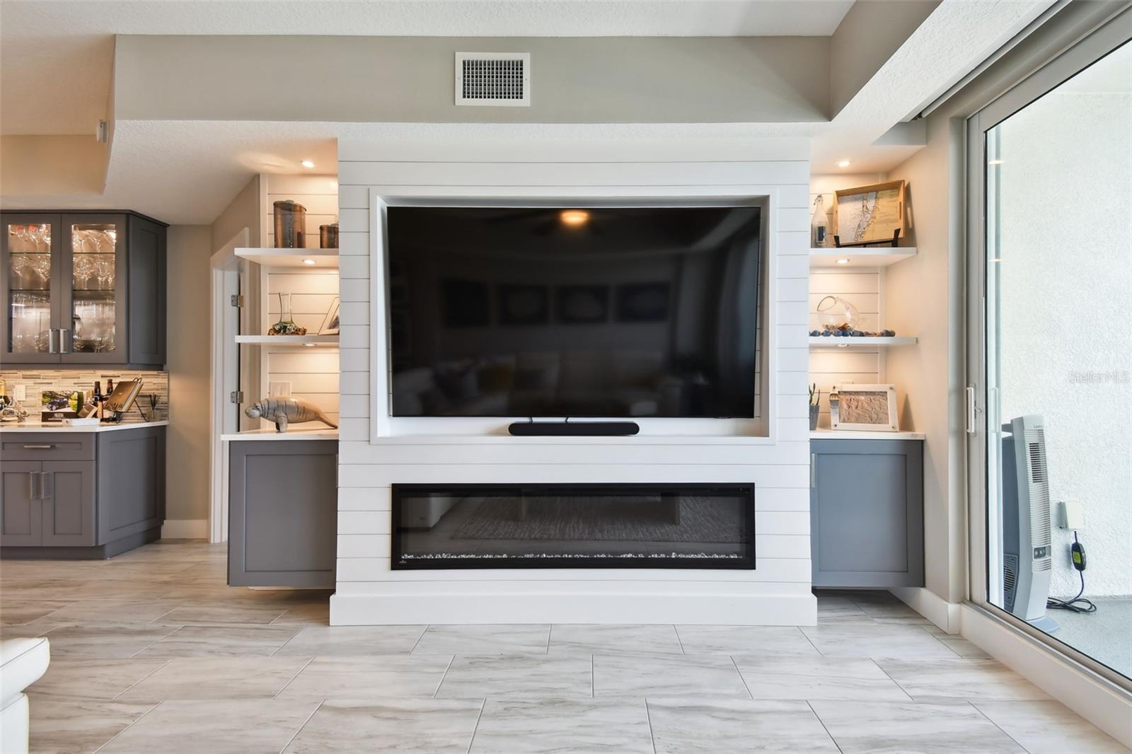Custom built in fireplace, shelving, lights, and cabinets