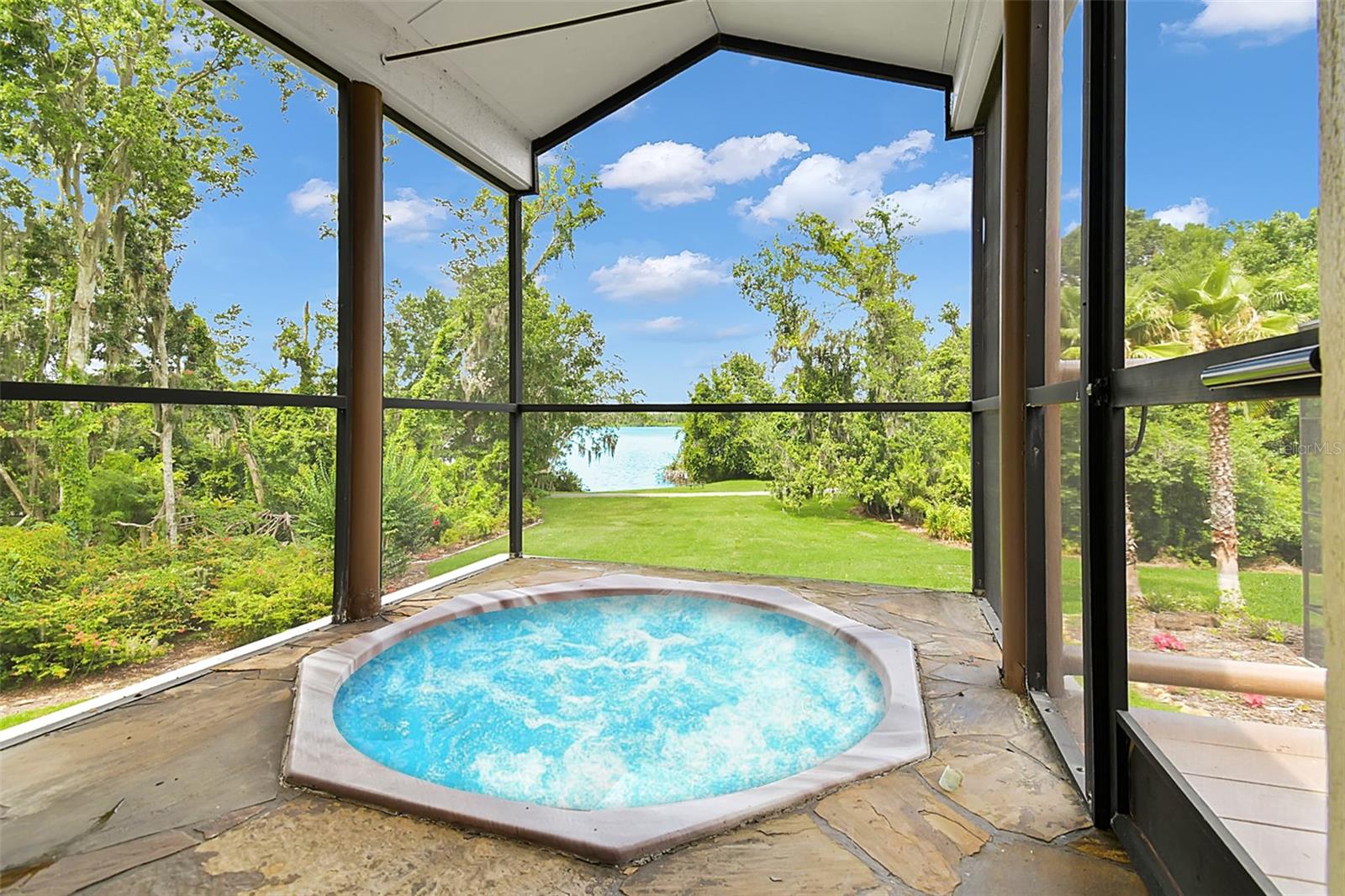 French doors lead to a private screened balcony with jacuzzi overlooking the lake.
