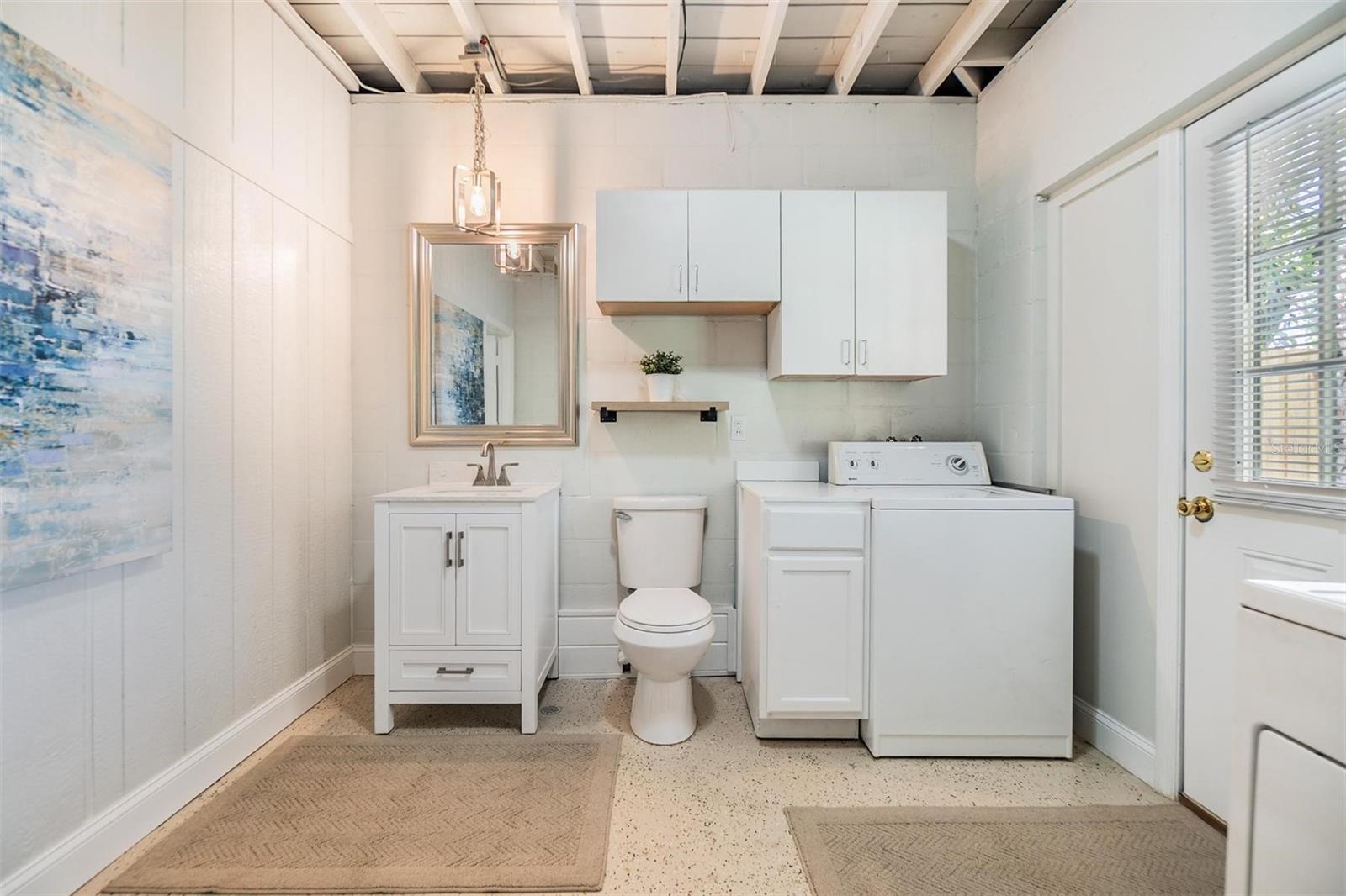 Half bath with laundry facilities adjacent to primary bedroom