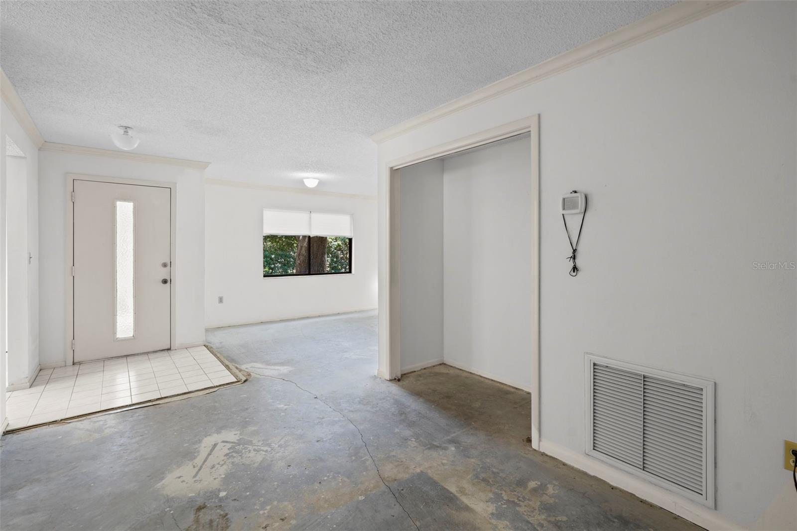 From dining room looking toward front door with liv. room and HVAC/utility closet on right,