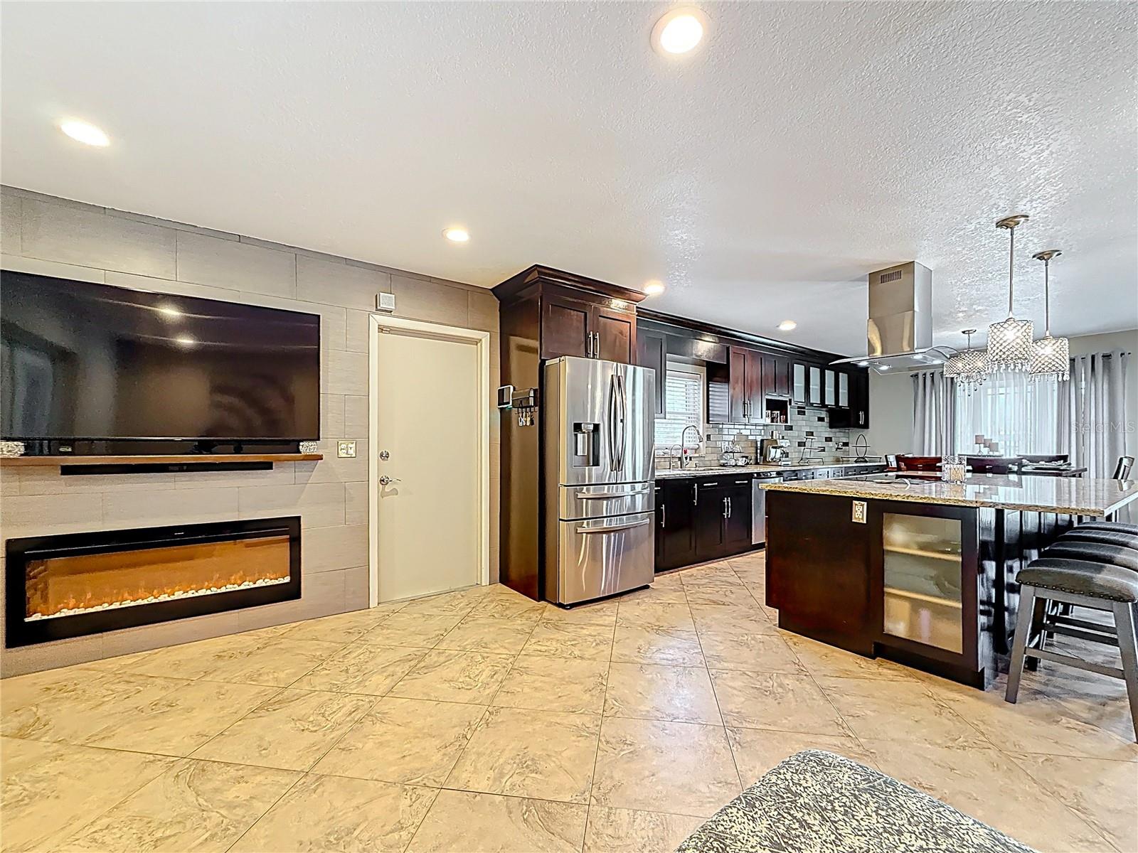 TV nook in kitchen area with built in electric fireplace, TV and surround sound system