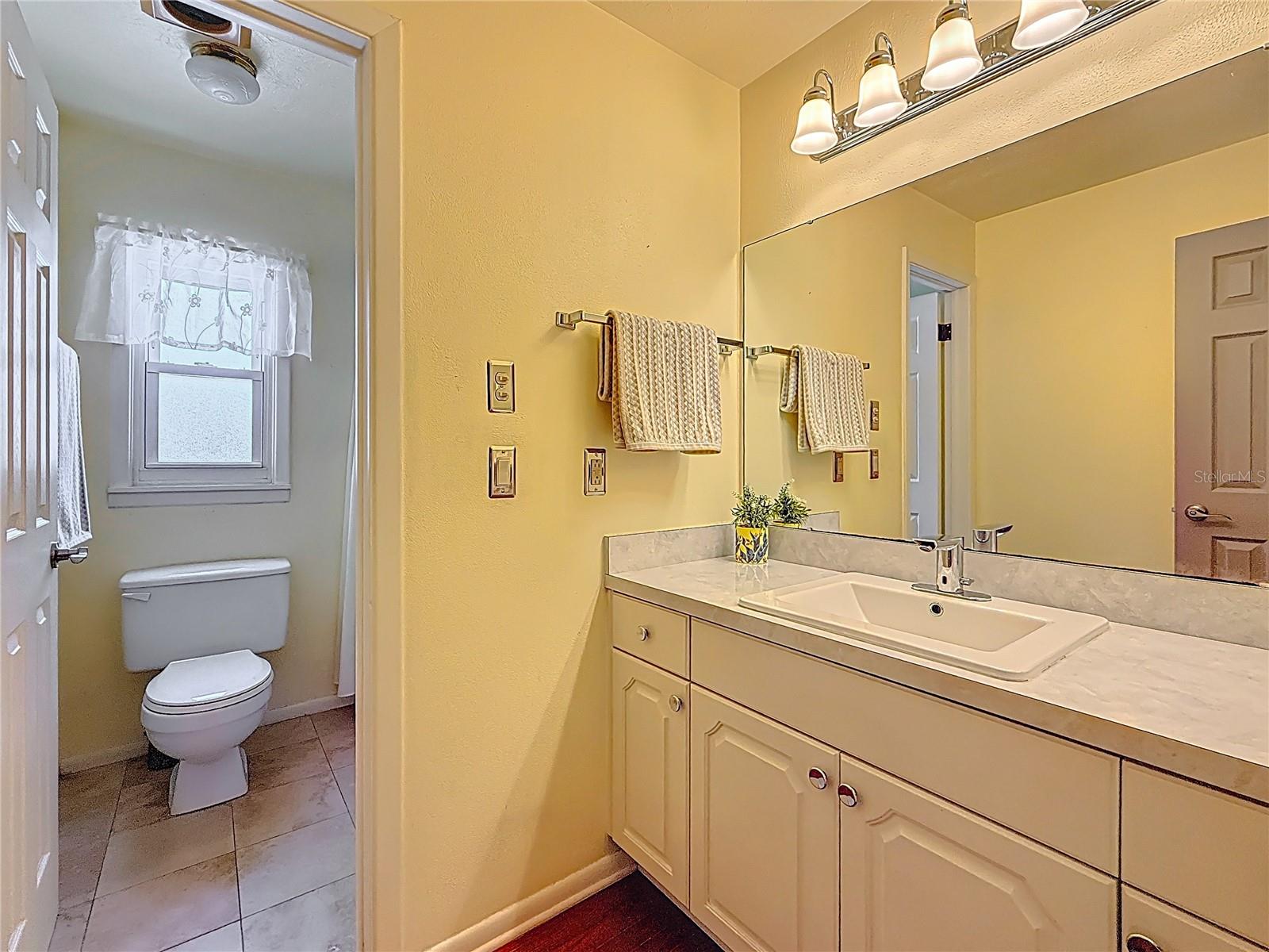 Second bathroom with tub shower and overhead heating lamp