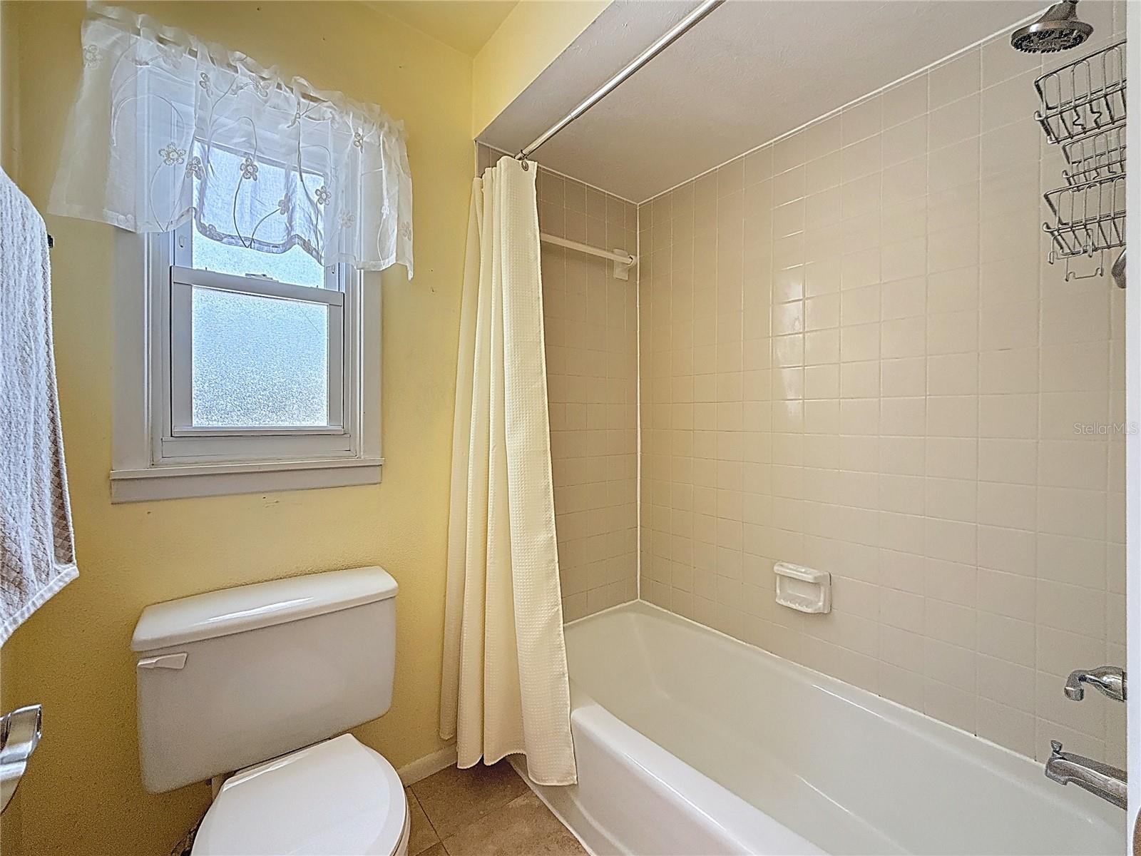 Second bathroom with tub shower and overhead heating lamp