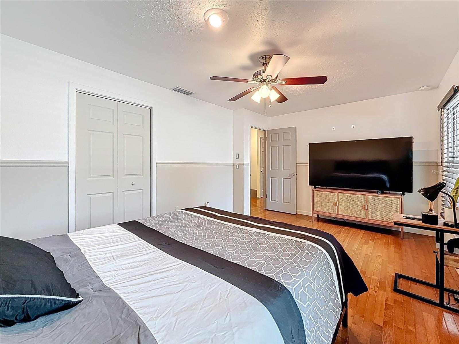 3rd bedroom with wood floor and walk in closet