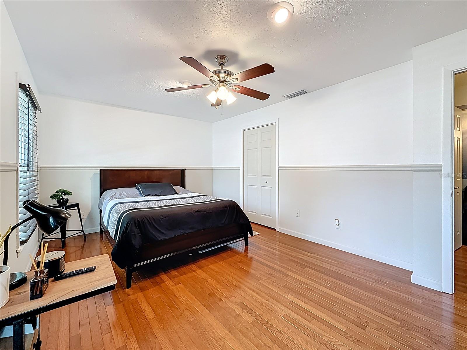 3rd bedroom with wood floor and walk in closet