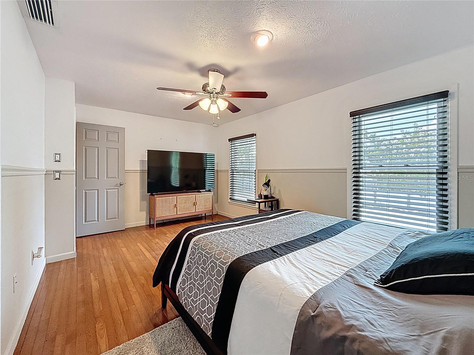 3rd bedroom with wood floor and walk in closet
