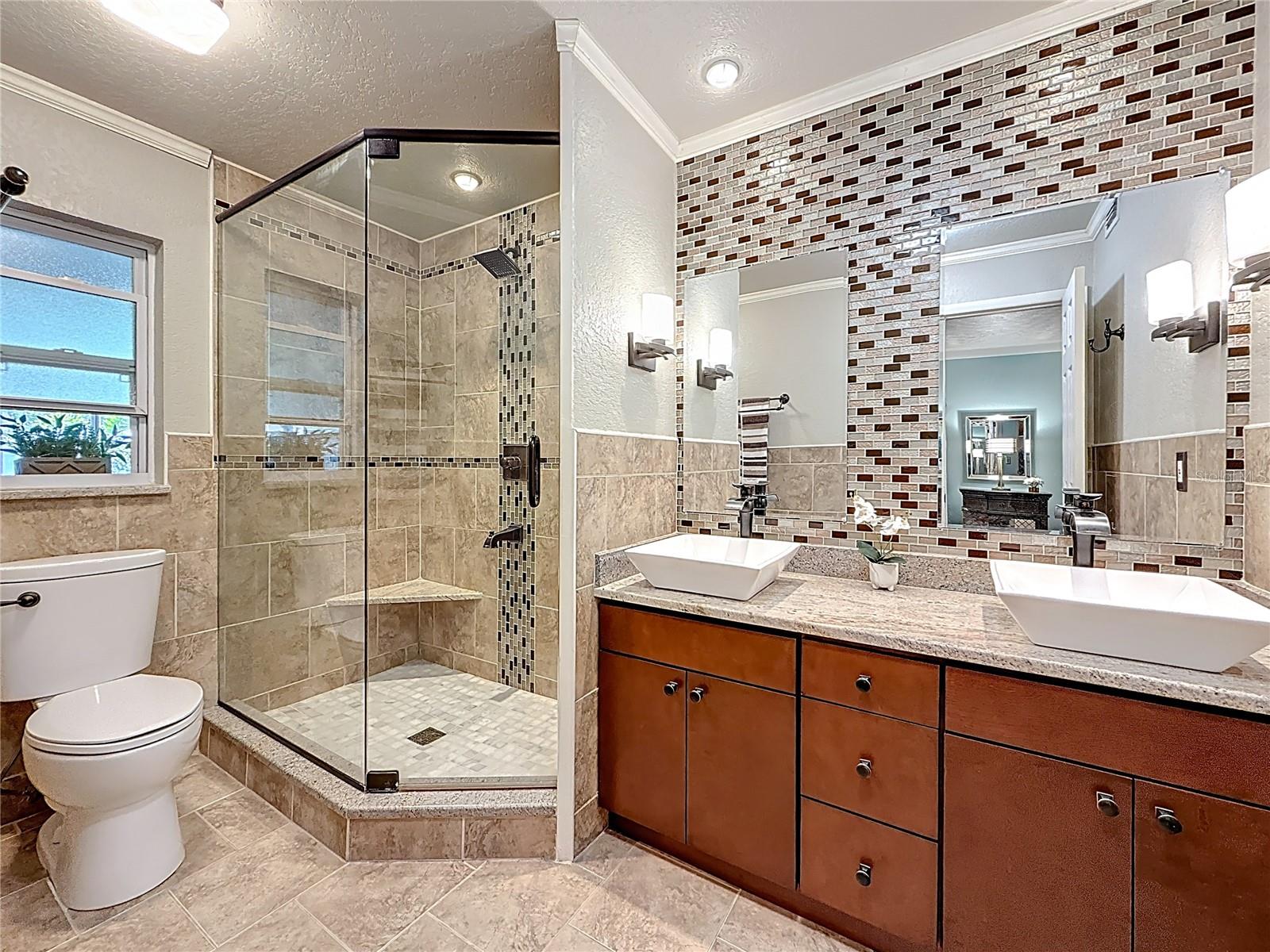 Ensuite barhroom with glass frame shower, granite top vanity and double sinks