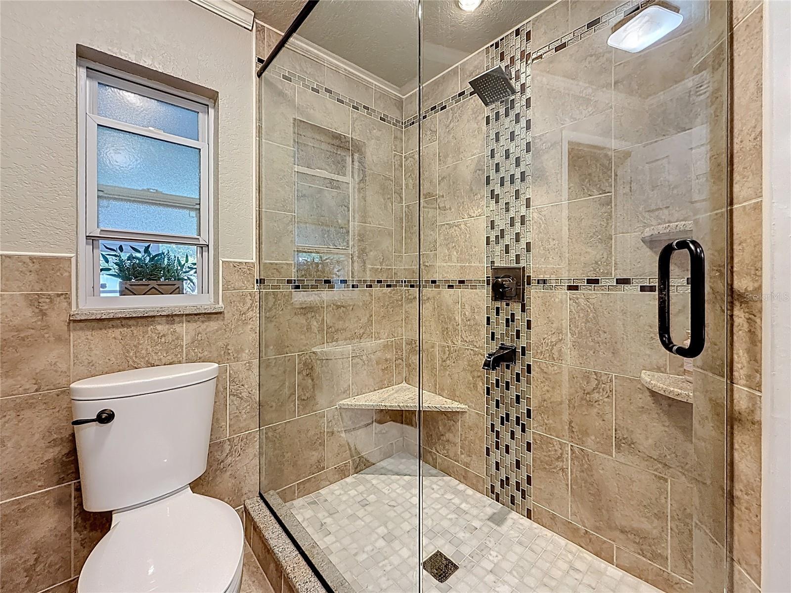 Ensuite barhroom with glass frame shower, granite top vanity and double sinks