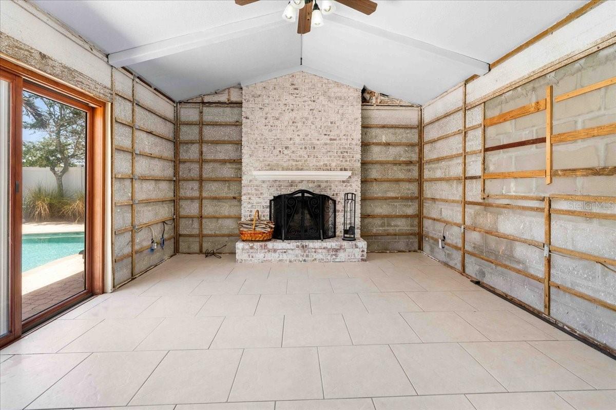 The Great Room with working fireplace and slider out to the pool area