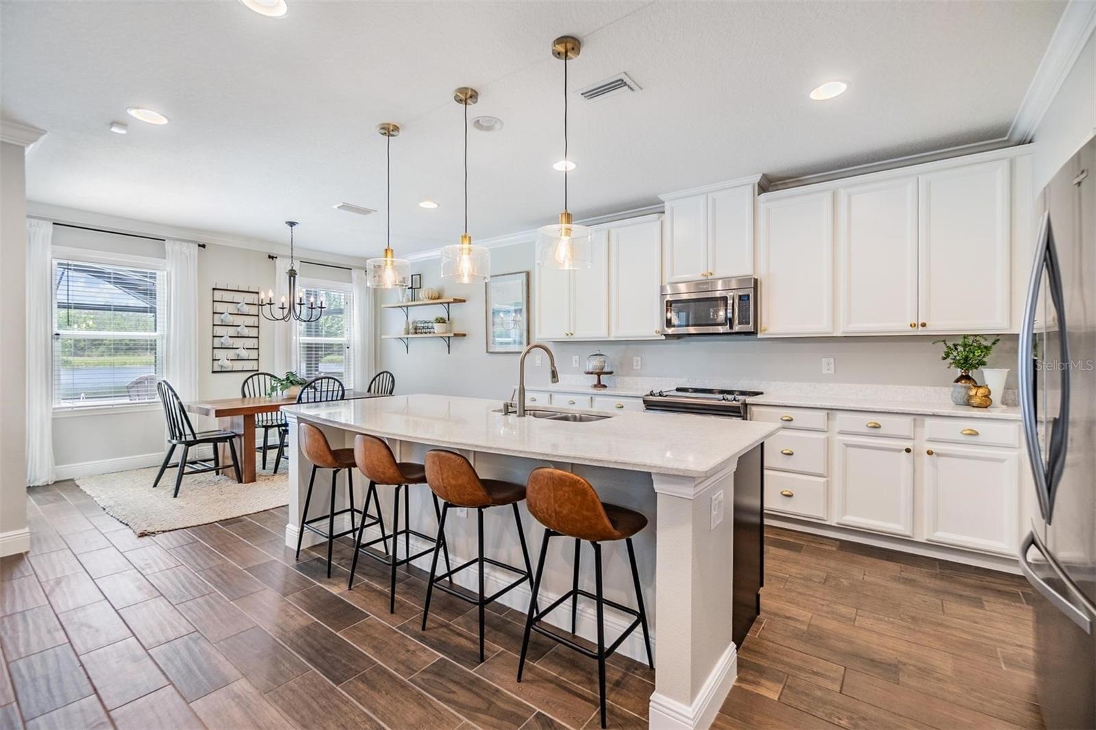 Crisp, white kitchen with designer pendent lighting