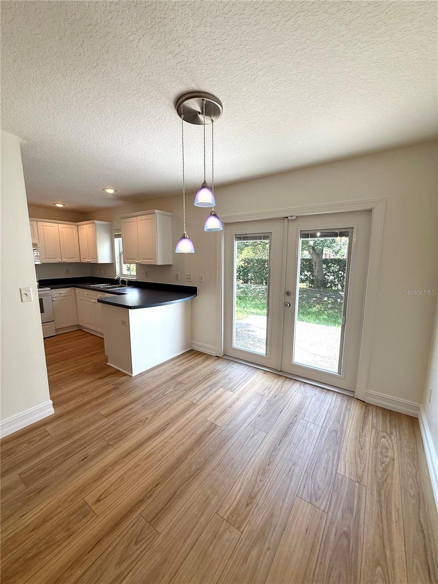 Stylish and full of character, this dining area is anchored by a stunning blue light fixture that adds a pop of color and elegance—creating the perfect setting for memorable meals and cozy gatherings.
