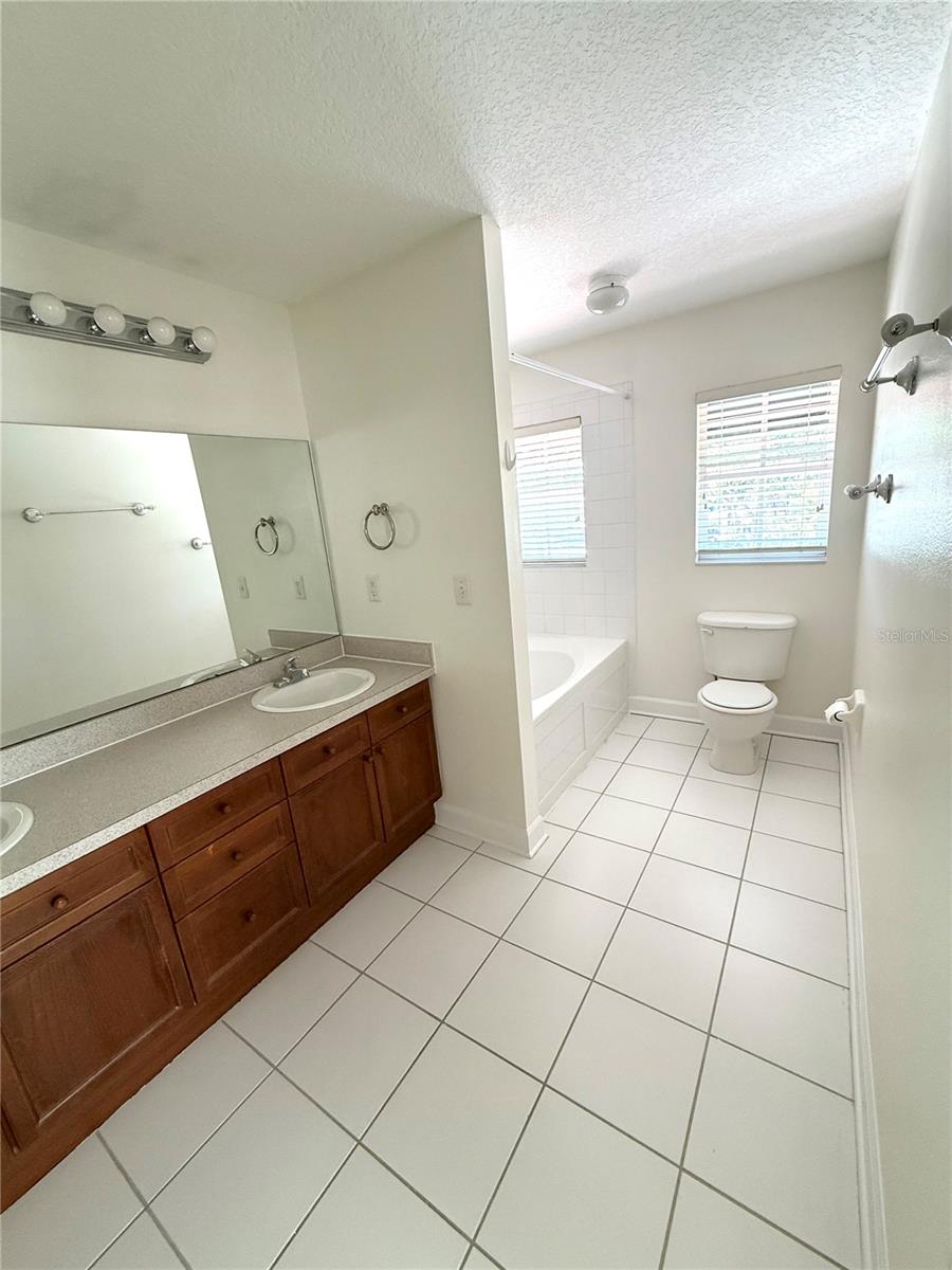 This spacious bathroom features dual sinks for added convenience, a relaxing bathtub, and a sleek toilet—designed for comfort, functionality, and everyday ease.