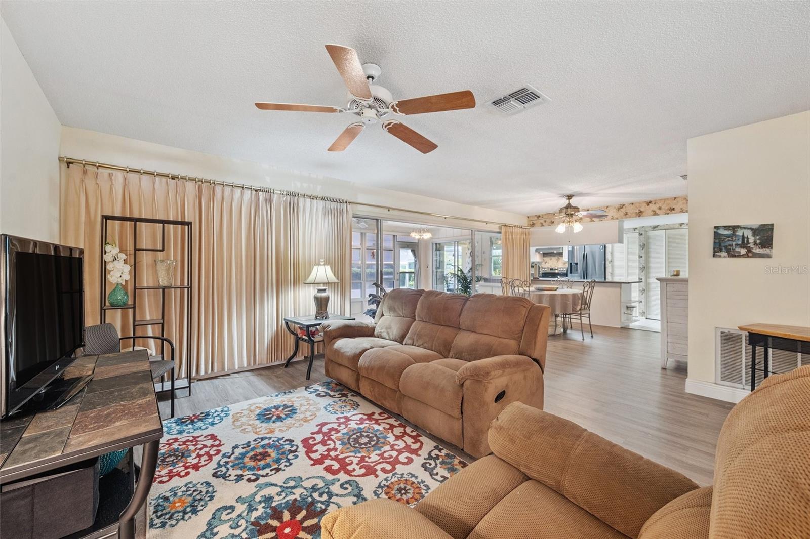 Living room with dining room and kitchen in the background, also shows the access to the oversized Florida Room