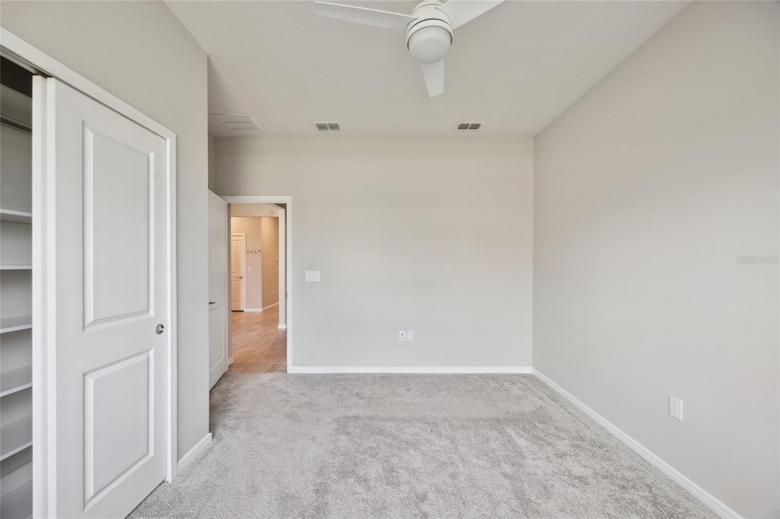 Bedroom 2 with built in closet , ceiling fan, blinds