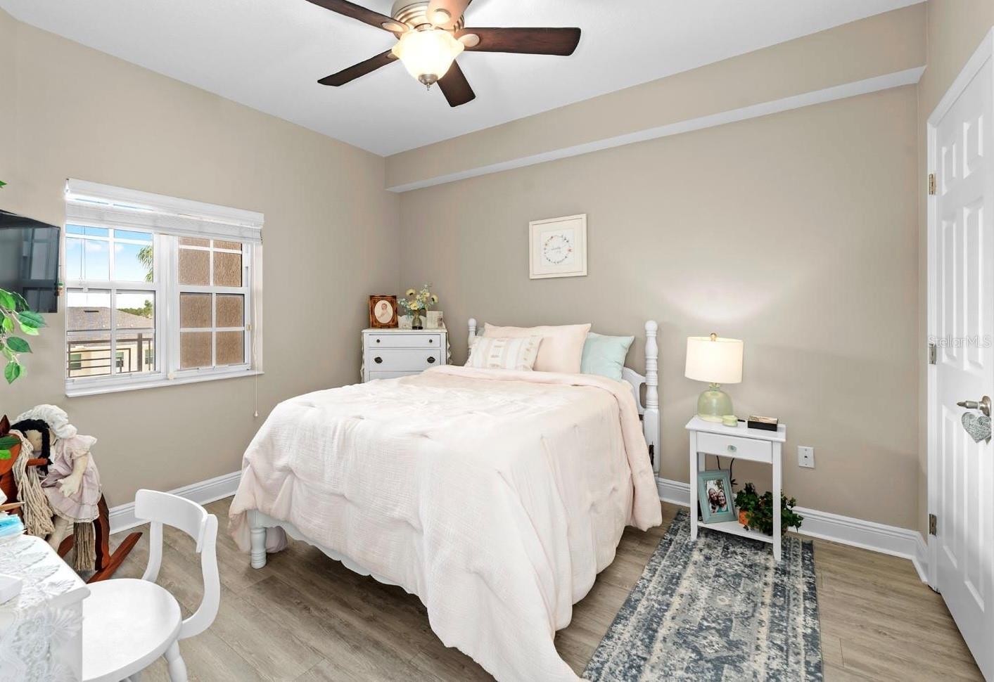 The guest bedroom has a walk-in closet, a lighted ceiling fan, and its own door to the second bathroom.