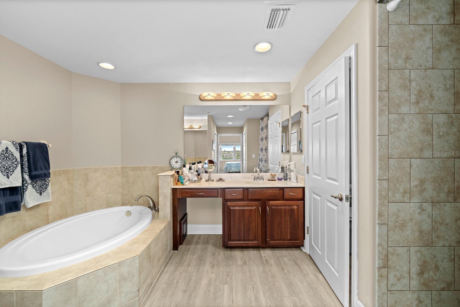 This luxurious and spacious ensuite wouldn't be complete without a large soaking  garden tub, updated lighting, a private water closet, and two separate vanities.