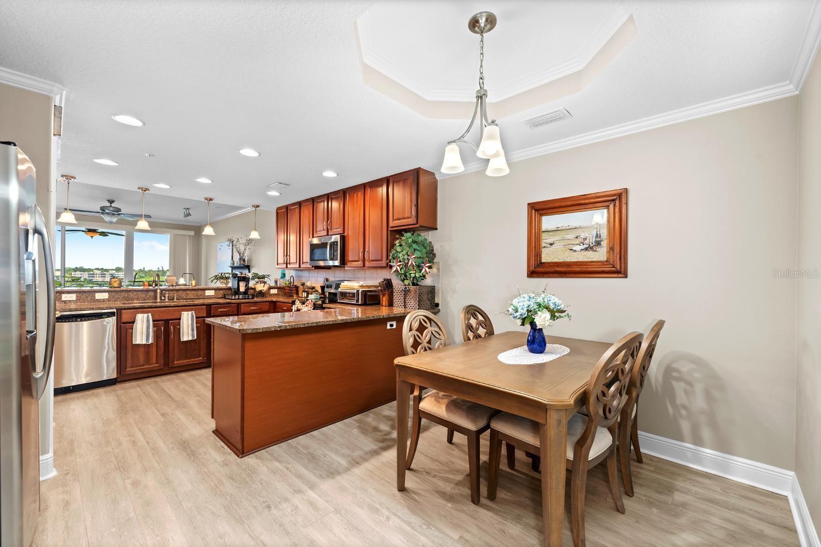 The kitchen includes an eat-in area with a tray ceiling, and it can accommodate a larger table if needed.  High quality LVP flooring covers every inch of this condo.