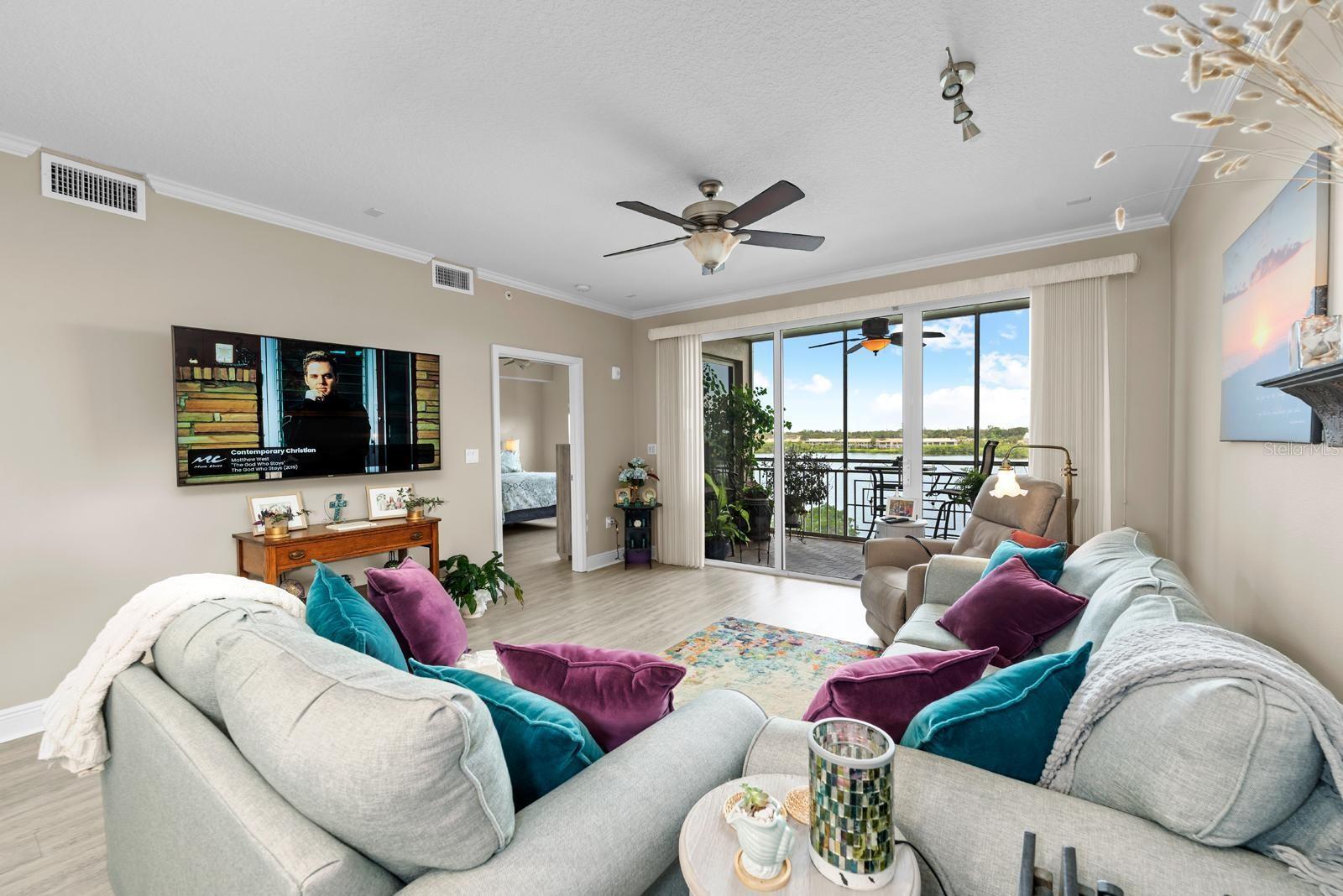 The large and spacious great room overlooks the water....you can even see the water from the couch!  The very high quality LVP flooring is newer, and is in every room of this condo!
