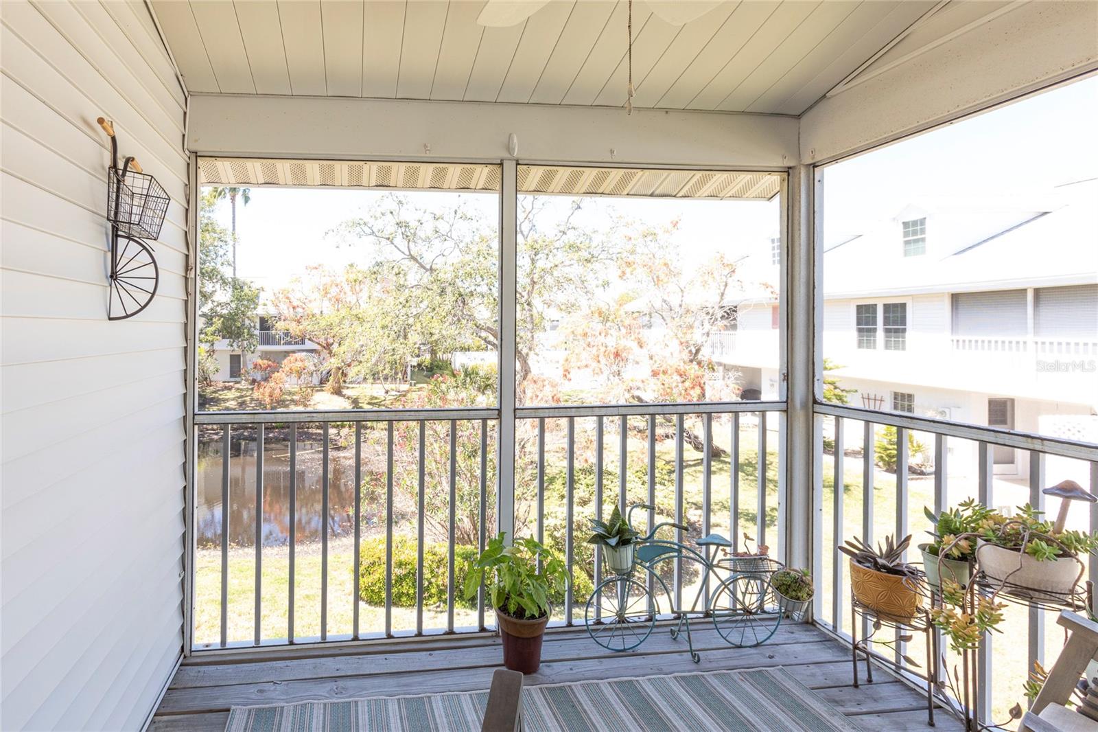 Screened in large patio with view of the pond