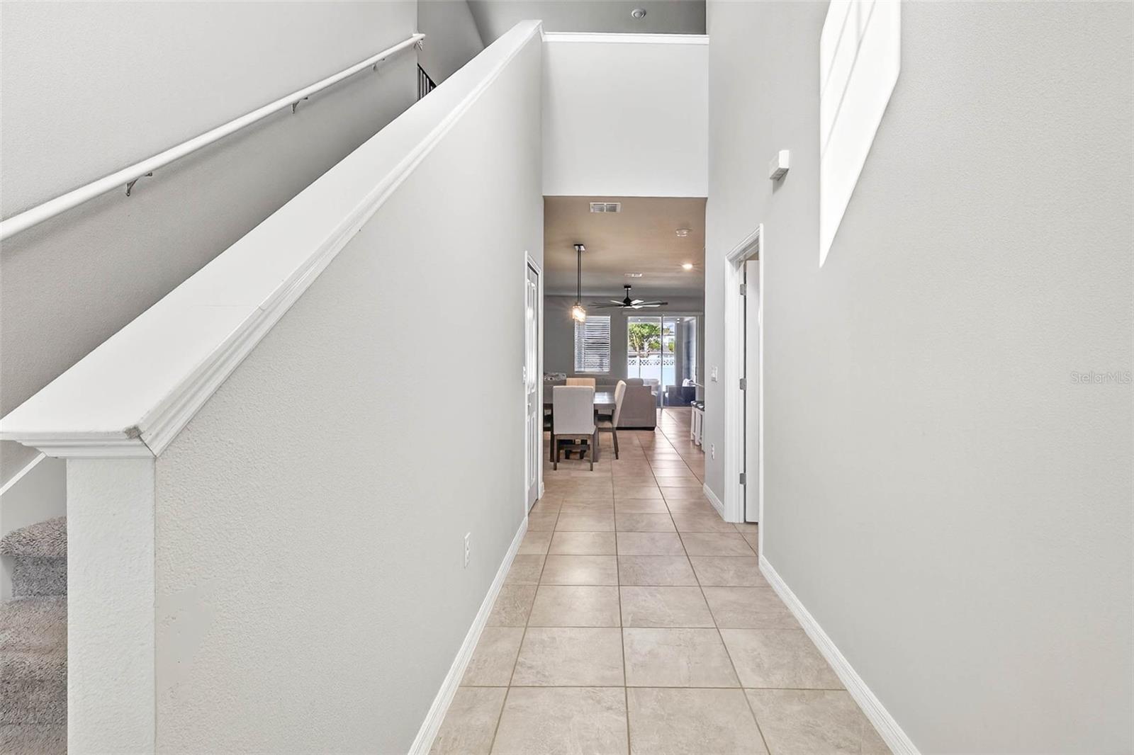 Two story entryway with fresh paint, tile flooring, leading to your open floor plan living room and kitchen.