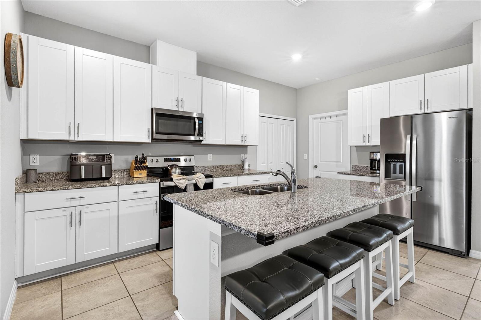 Your kitchen has white shaker cabinetry, quartz countertops, stainless steel appliances, and island seating.  Closet pantry and laundry room.